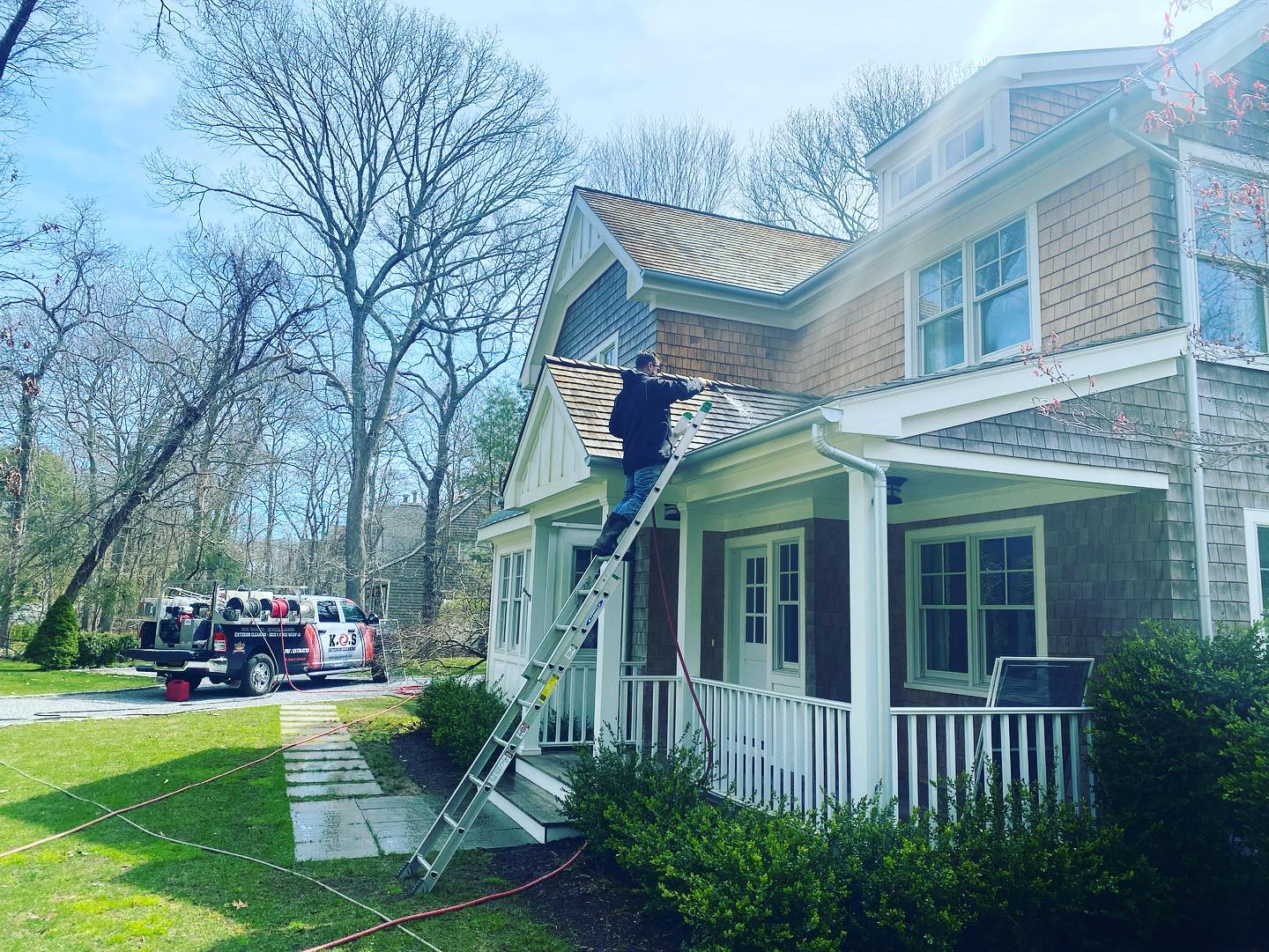 a man is standing on a ladder on the front of a house .