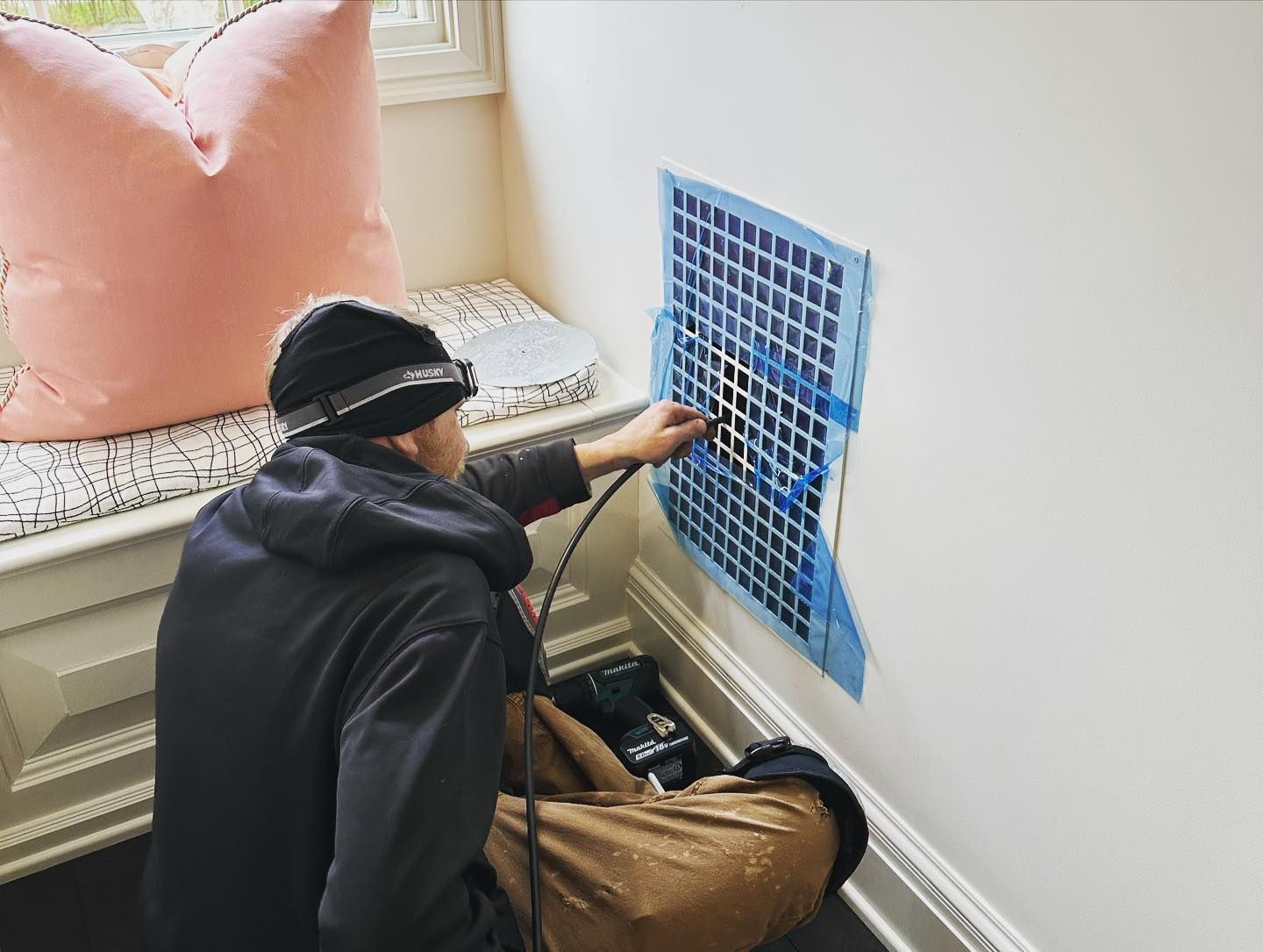 a man is sitting on the floor painting a picture on a wall .