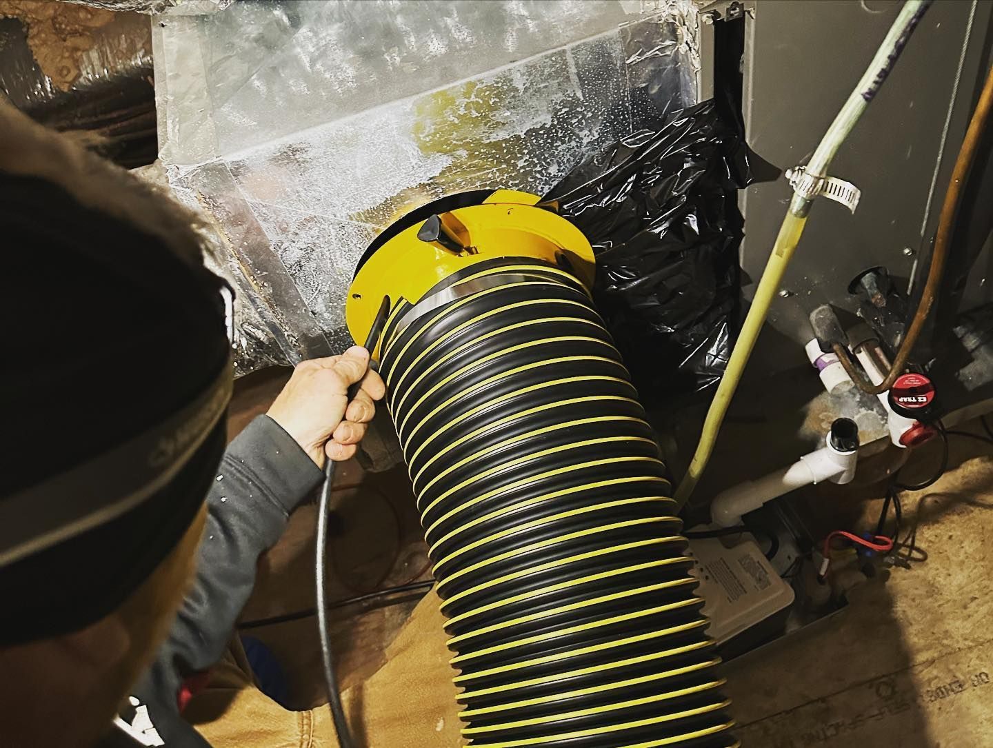 Connecting truck mounted HVAC cleaning hose to air ducts at a home on Long Island