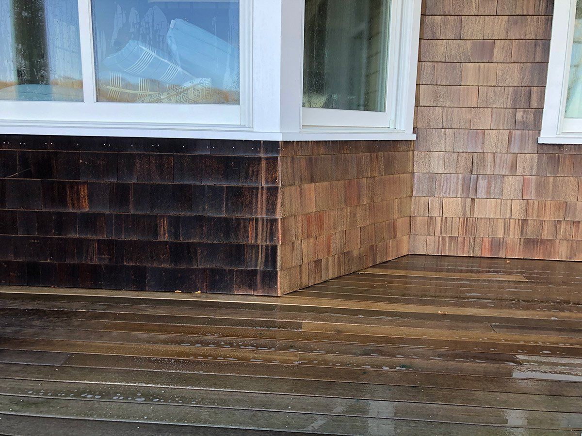 a wooden deck in front of a house with a window