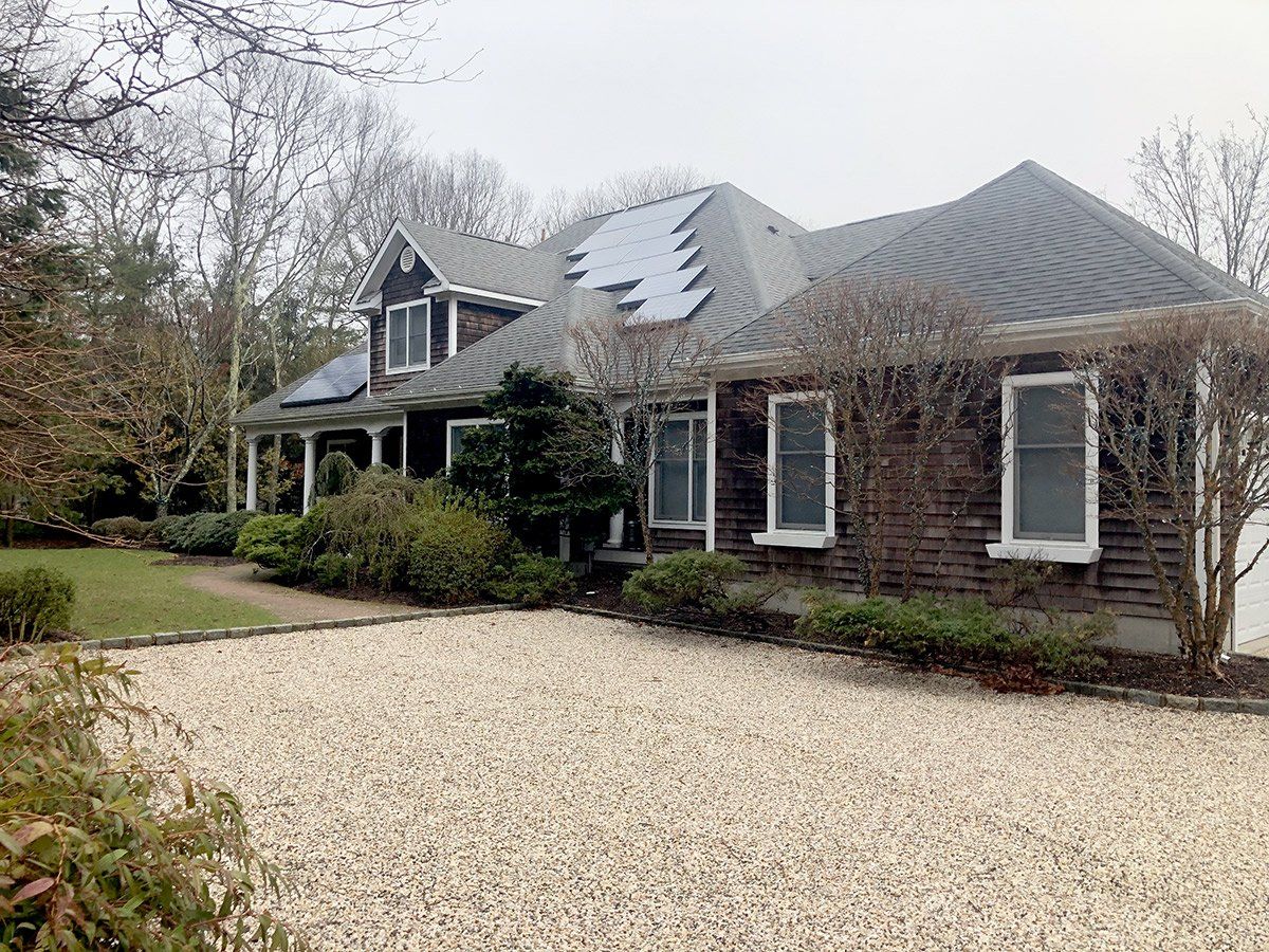 a large house with a gravel driveway in front of it .