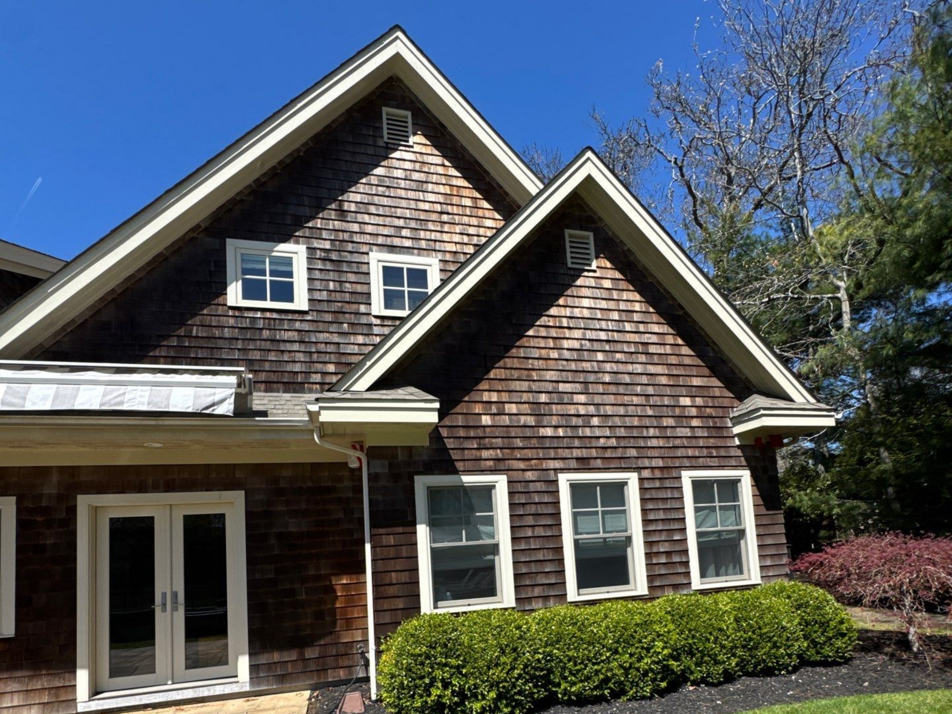 Soft washing solution starting to break up the organic growth on the cedar shake siding in Westhampton NY