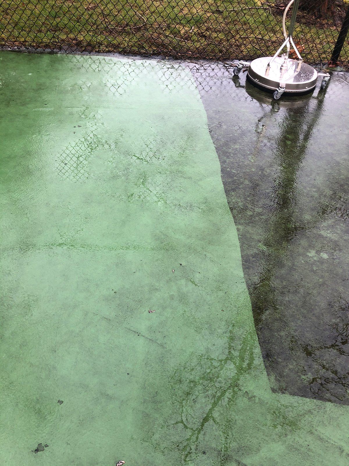 a green concrete surface is being cleaned with a machine .