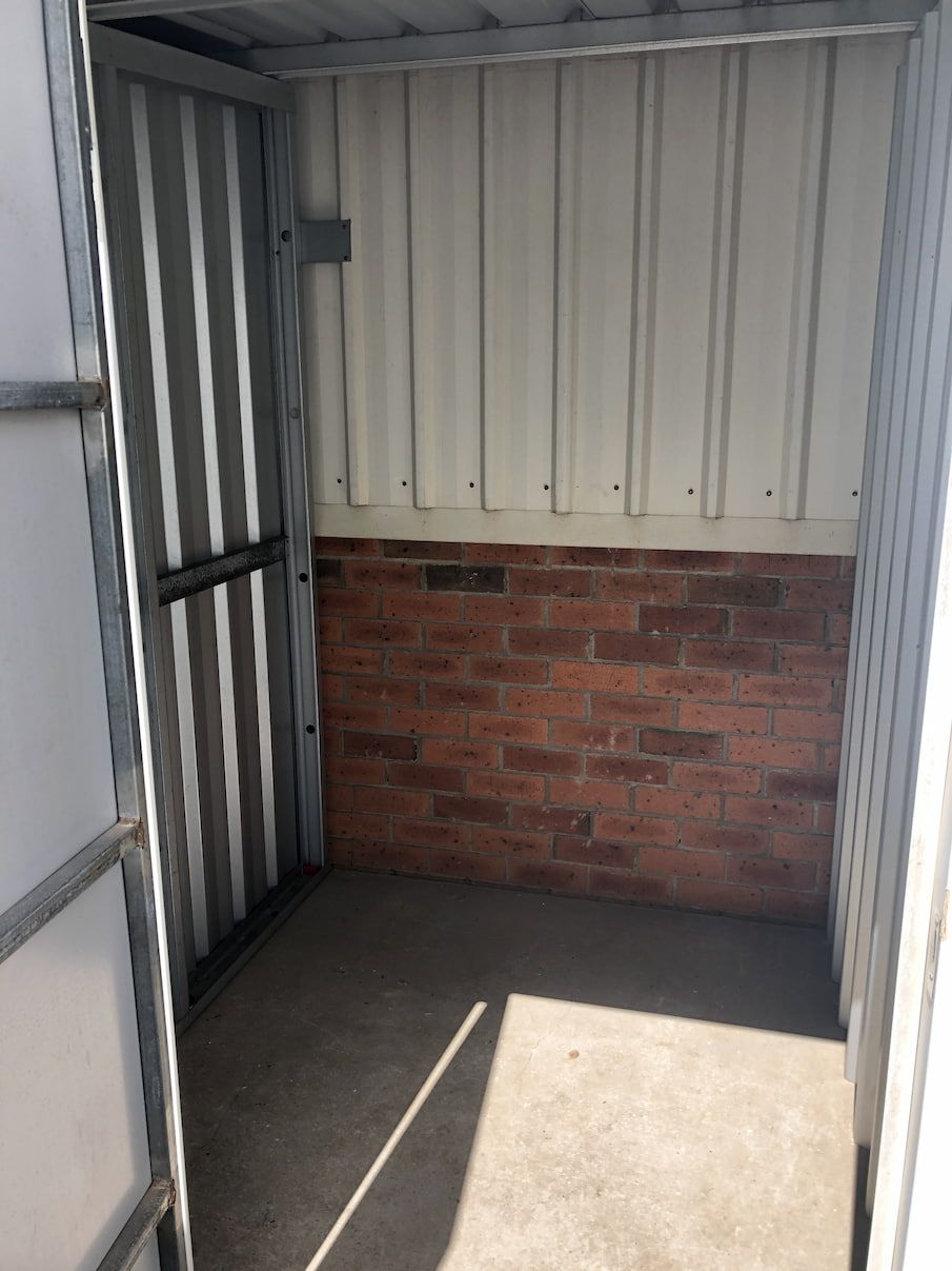A Small Room With A Brick Wall And A Door — Acacia Mini Storage in Port Macquarie, NSW