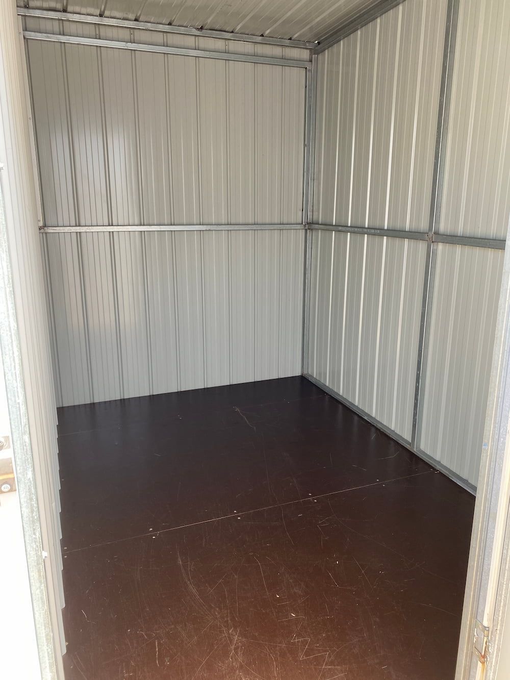 An Empty Shed With A Brown Floor And White Walls  — Acacia Mini Storage in Port Macquarie, NSW