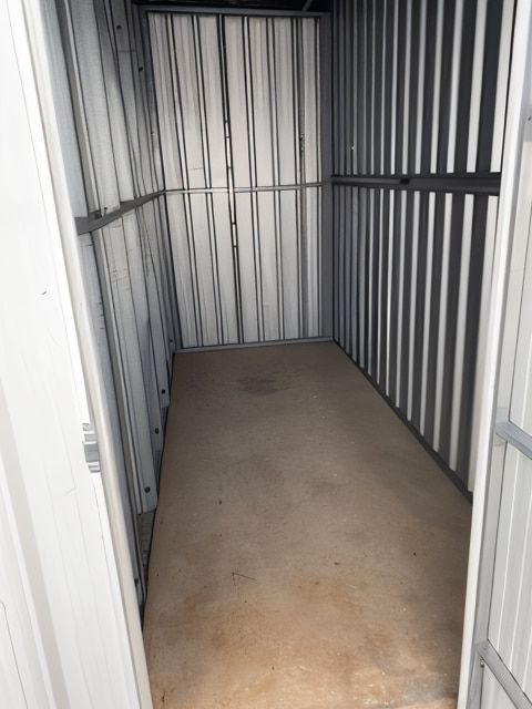 An Empty Storage Container With A Door Open And A Concrete Floor  — Acacia Mini Storage in Port Macquarie, NSW