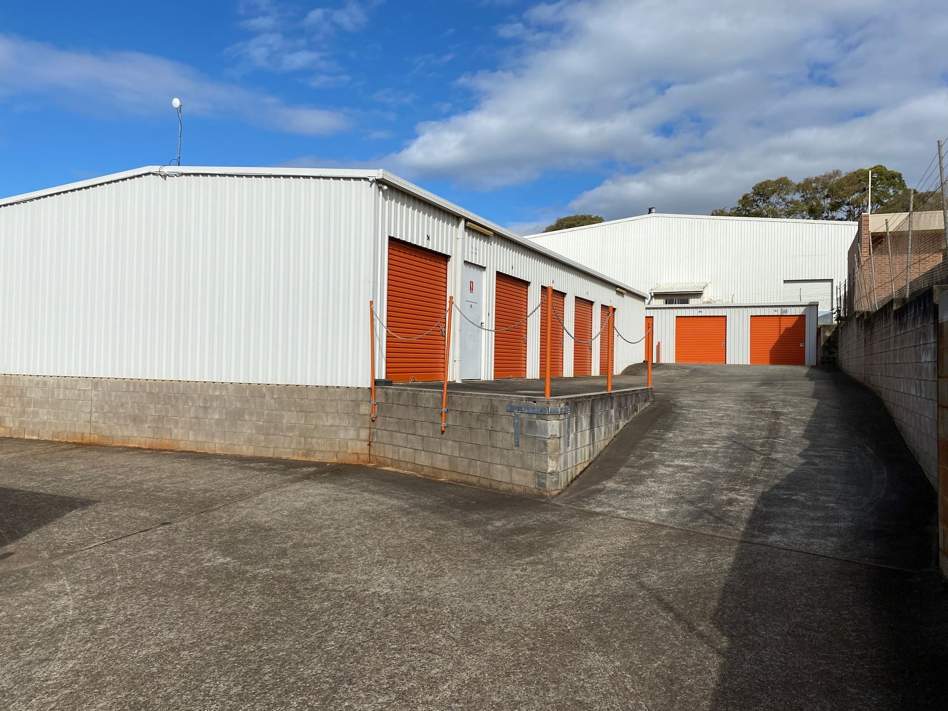 A row of storage units with orange doors on a sunny day — Acacia Mini Storage in Port Macquarie, NSW