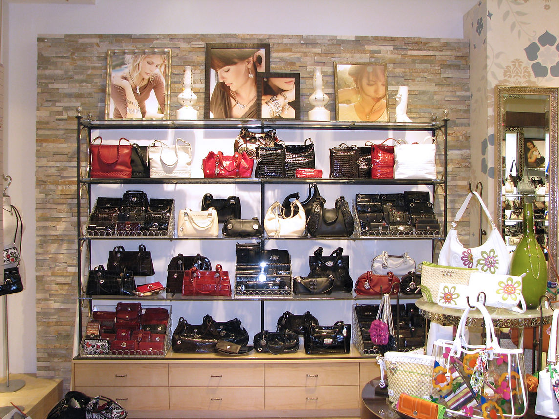 Handbags and accessories displayed on shelves in a boutique shop interior