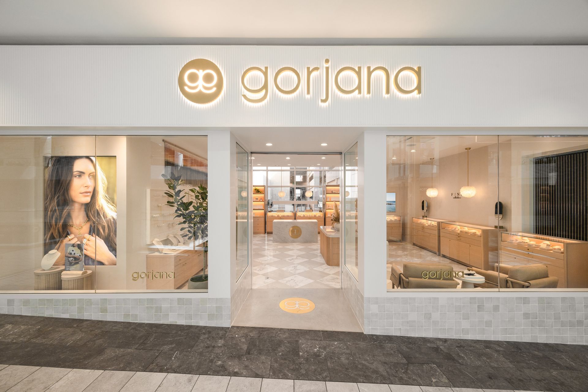 Gorjana jewelry store storefront with bright glass displays and gold logo sign