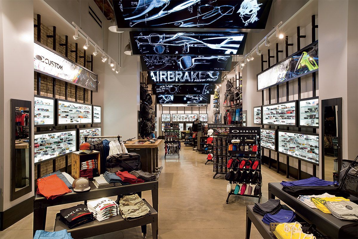 Modern store interior with shelves of merchandise and bright display cases, viewed down a central aisle