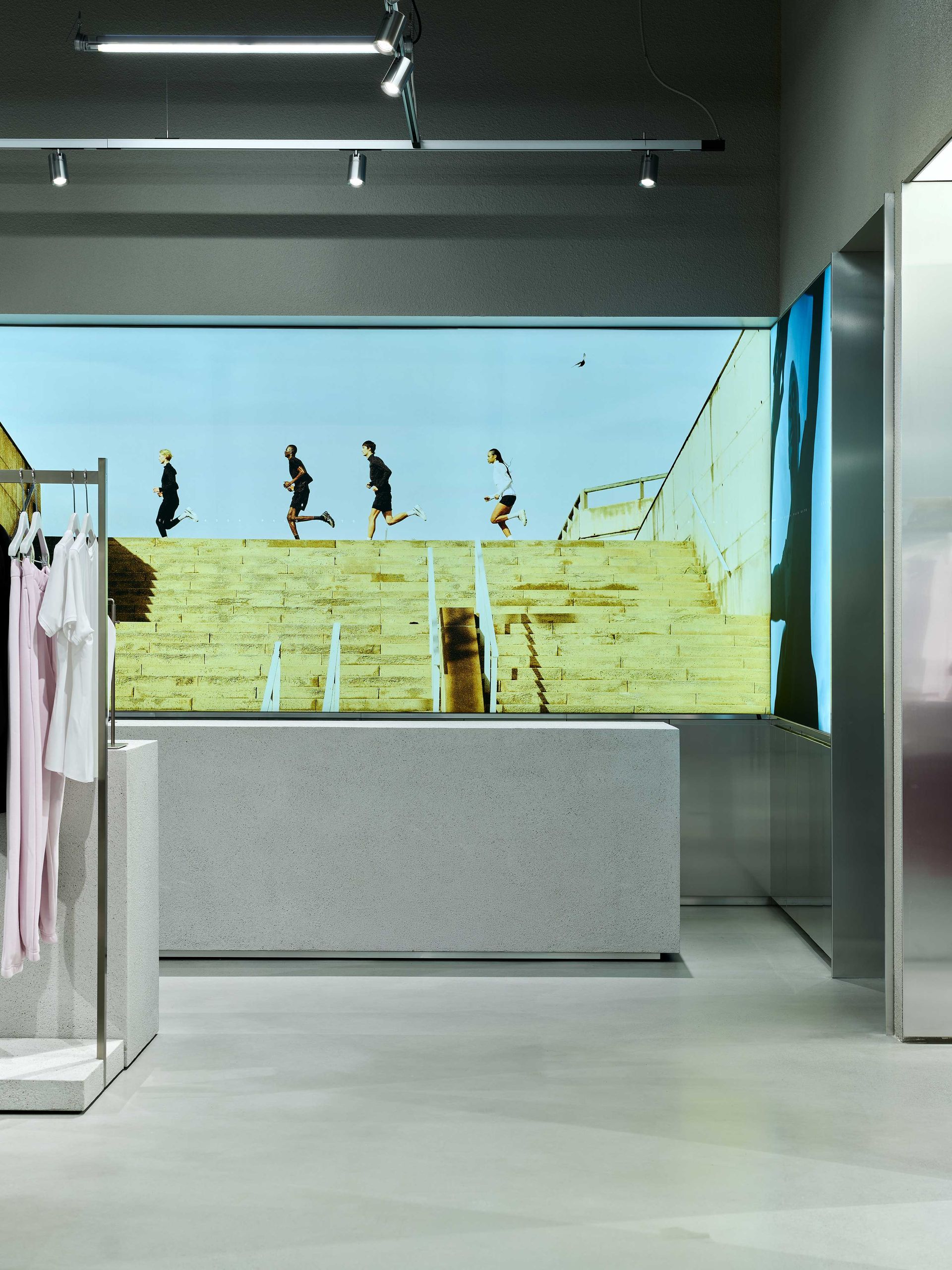 Art gallery interior with a large landscape painting and sculptures under bright overhead lights
