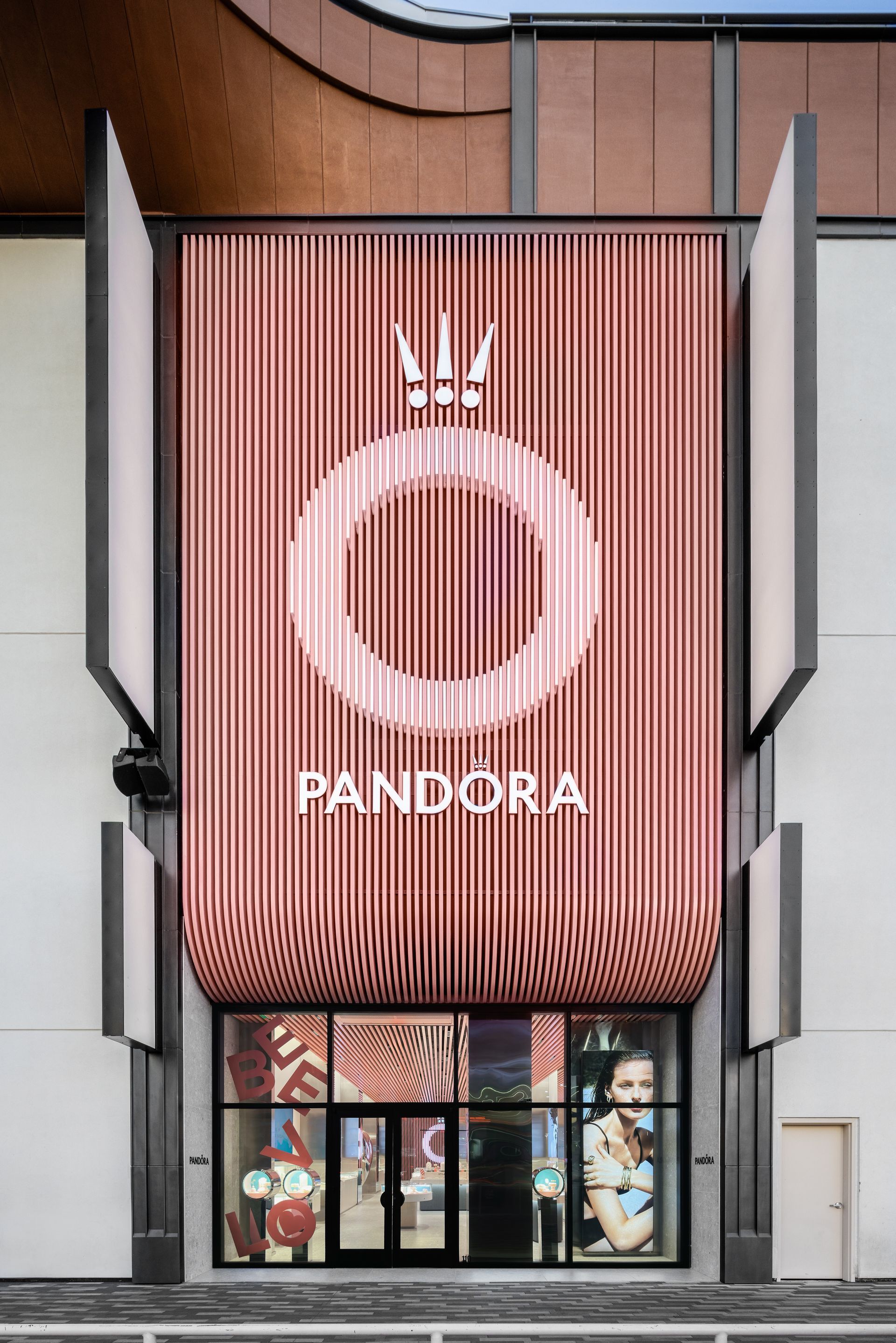 Pandora storefront with pink striped facade and logo above entrance