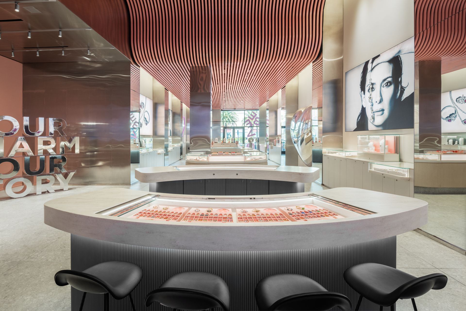Modern cafe interior with curved counter, black stools, striped ceiling, and large portrait mural
