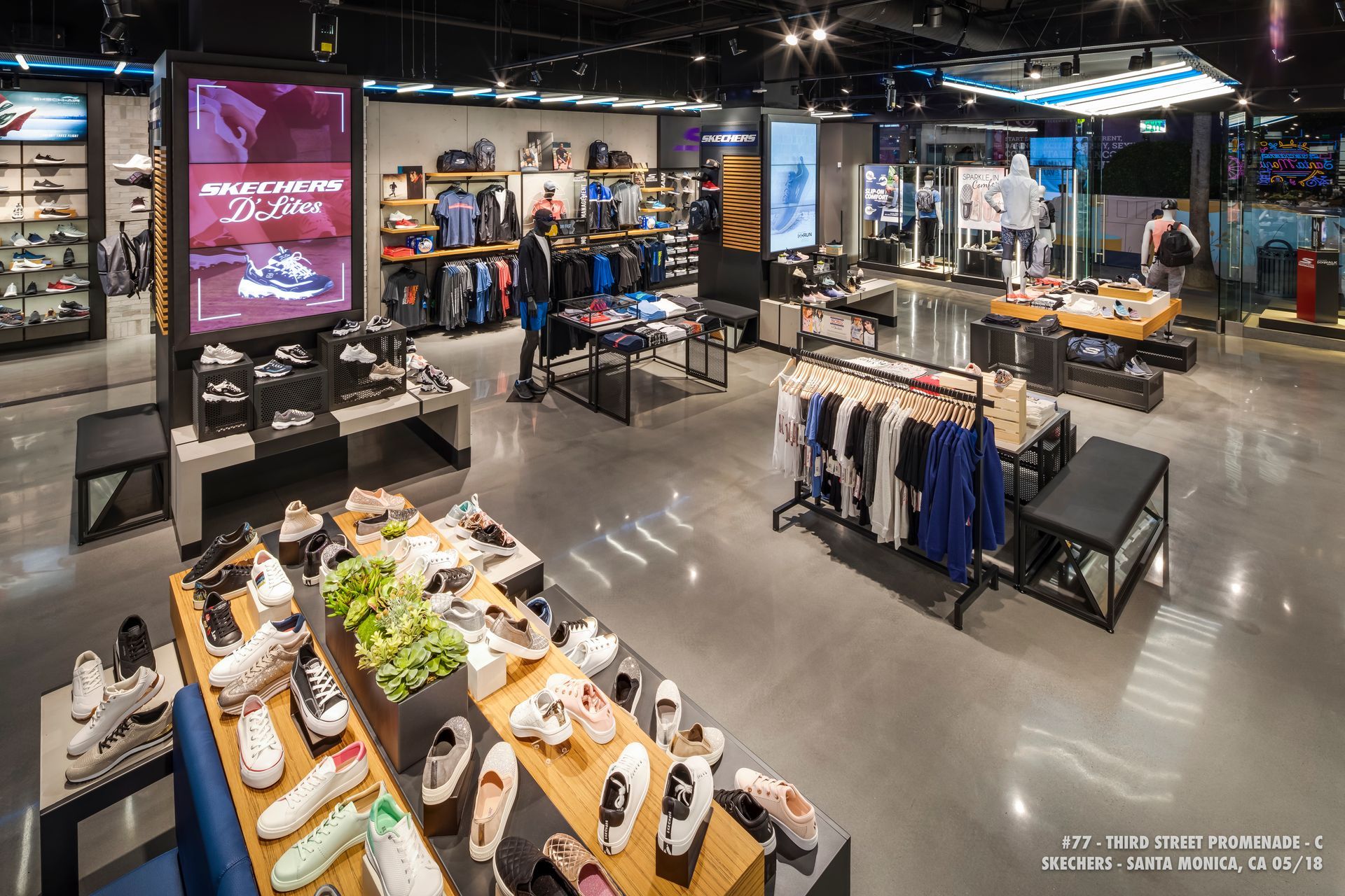 Clothing store interior with racks of shirts and accessories under bright retail lighting