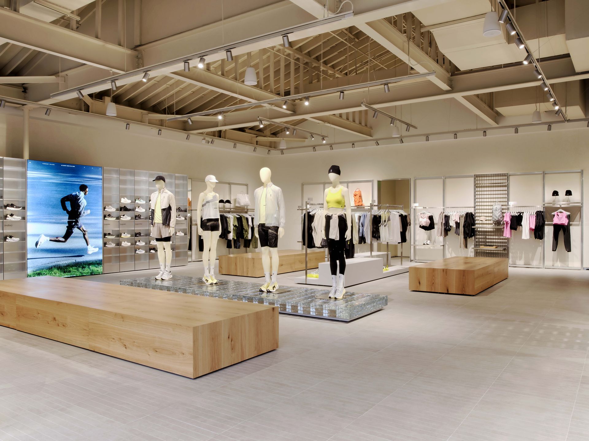 Modern sportswear store interior with mannequins, clothing racks, and wooden display benches