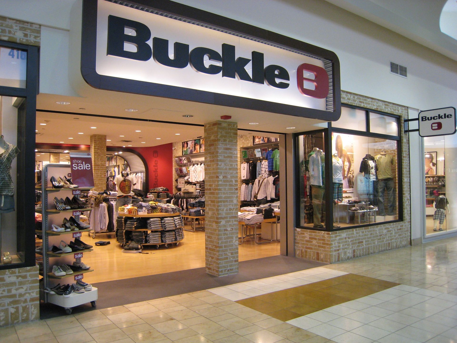 Buckle clothing store storefront in a shopping mall, with displays visible through the open entrance.