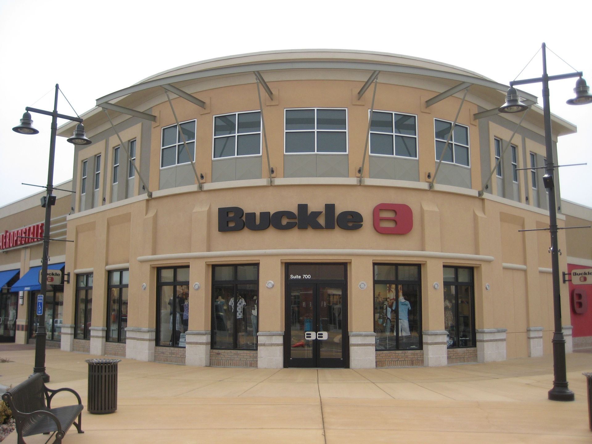 Buckle store storefront with tan facade and large windows in a shopping plaza