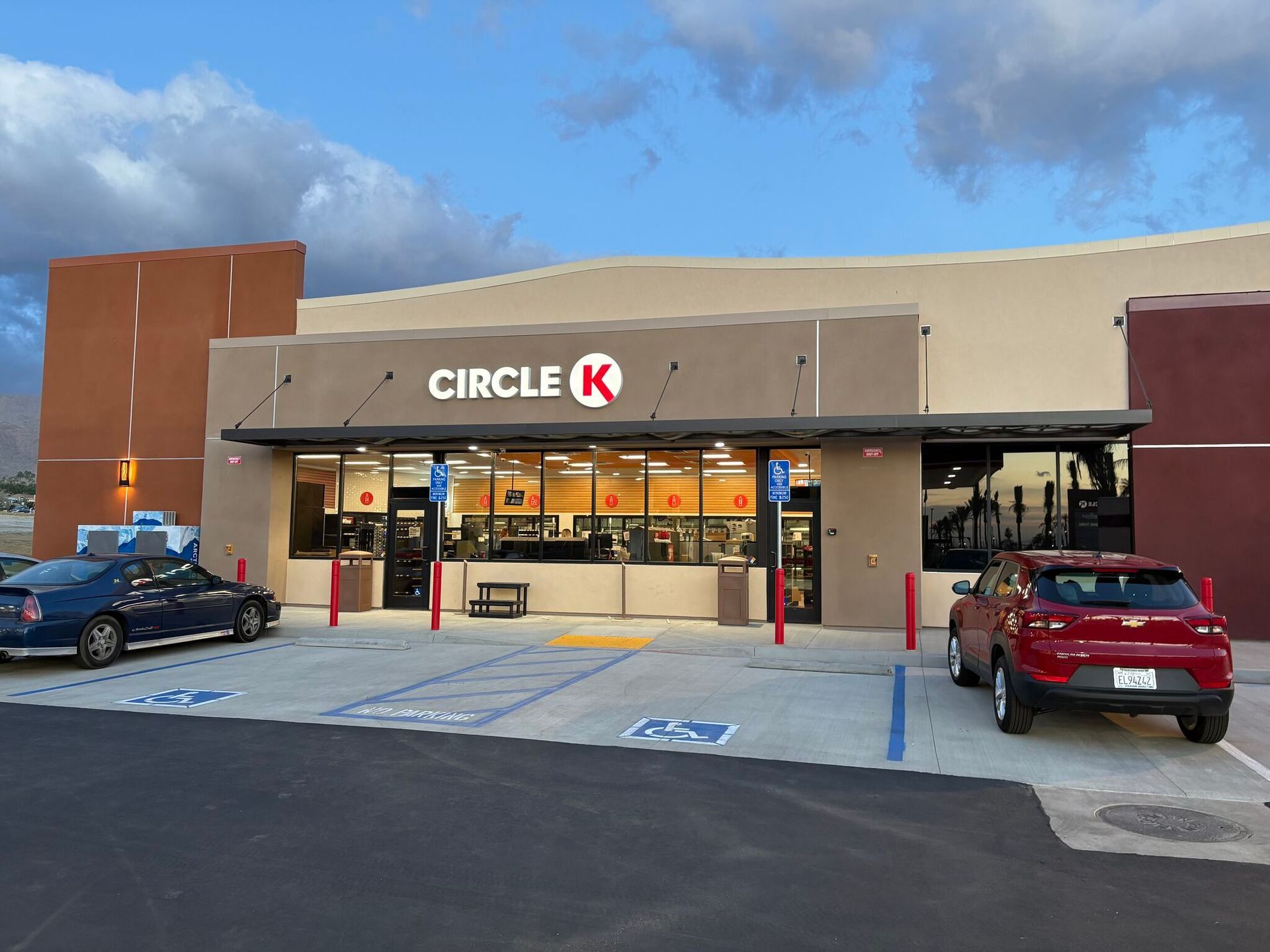Circle K storefront at dusk with parked cars and blue handicap spaces in front