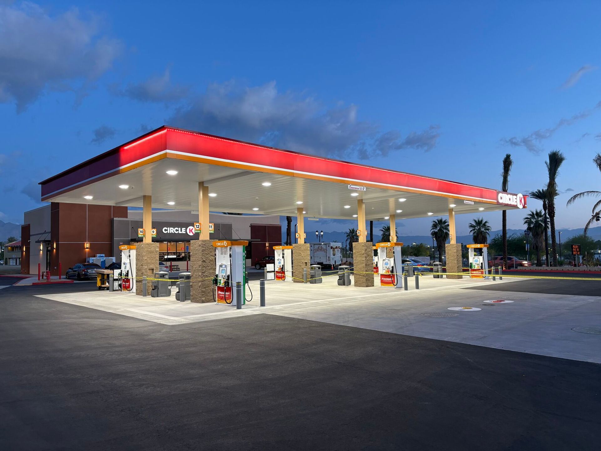 Gas station canopy with fuel pumps at dusk under a blue sky