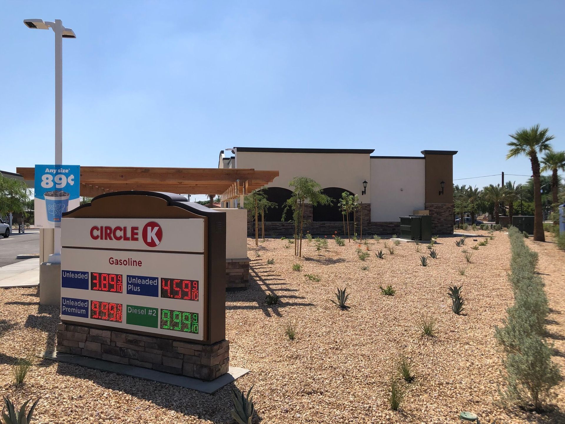 Circle K gas station sign beside a tan building in a desert lot under a clear blue sky