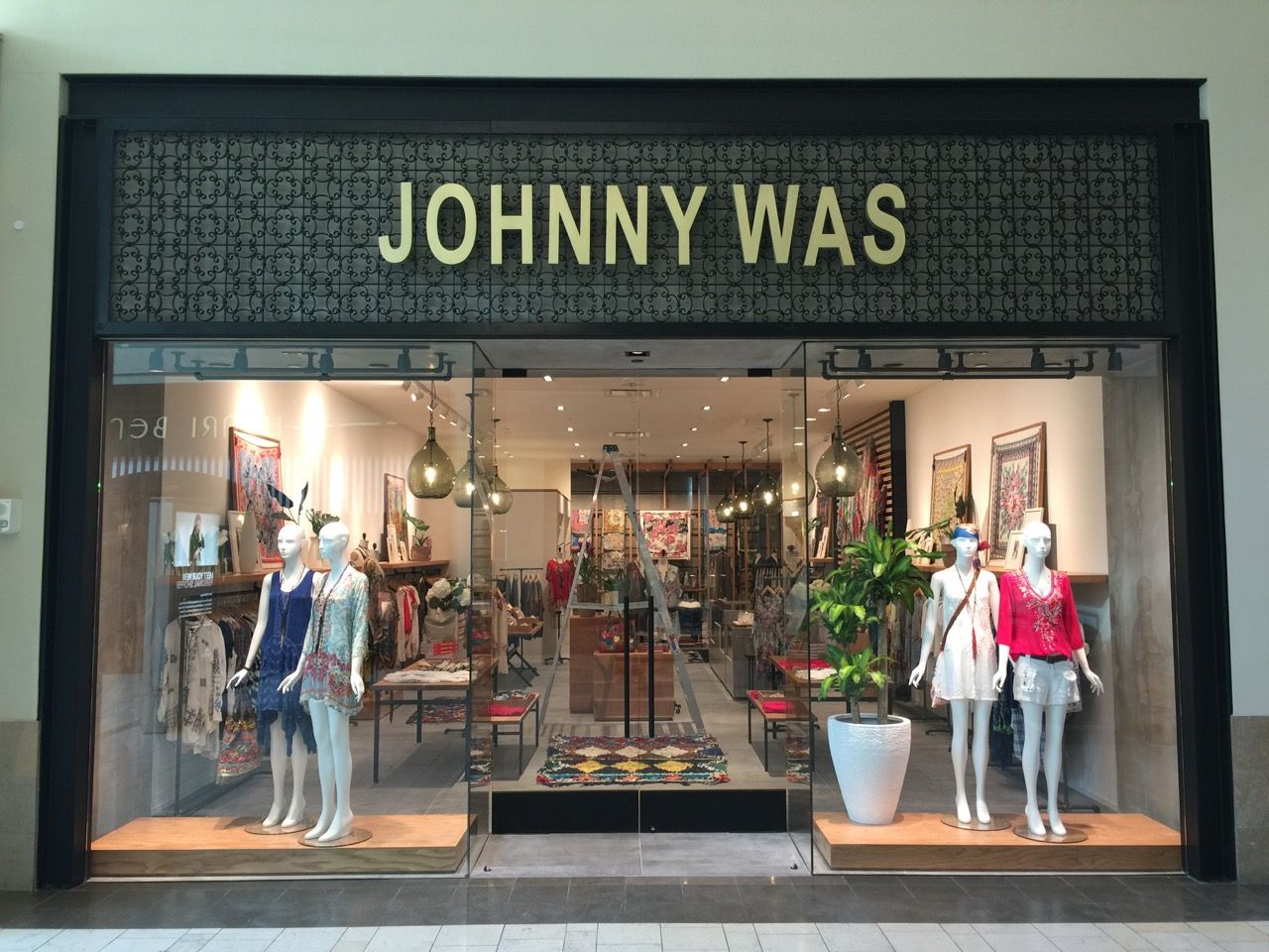 JOHNNY WAS clothing store storefront with mannequins in the display window