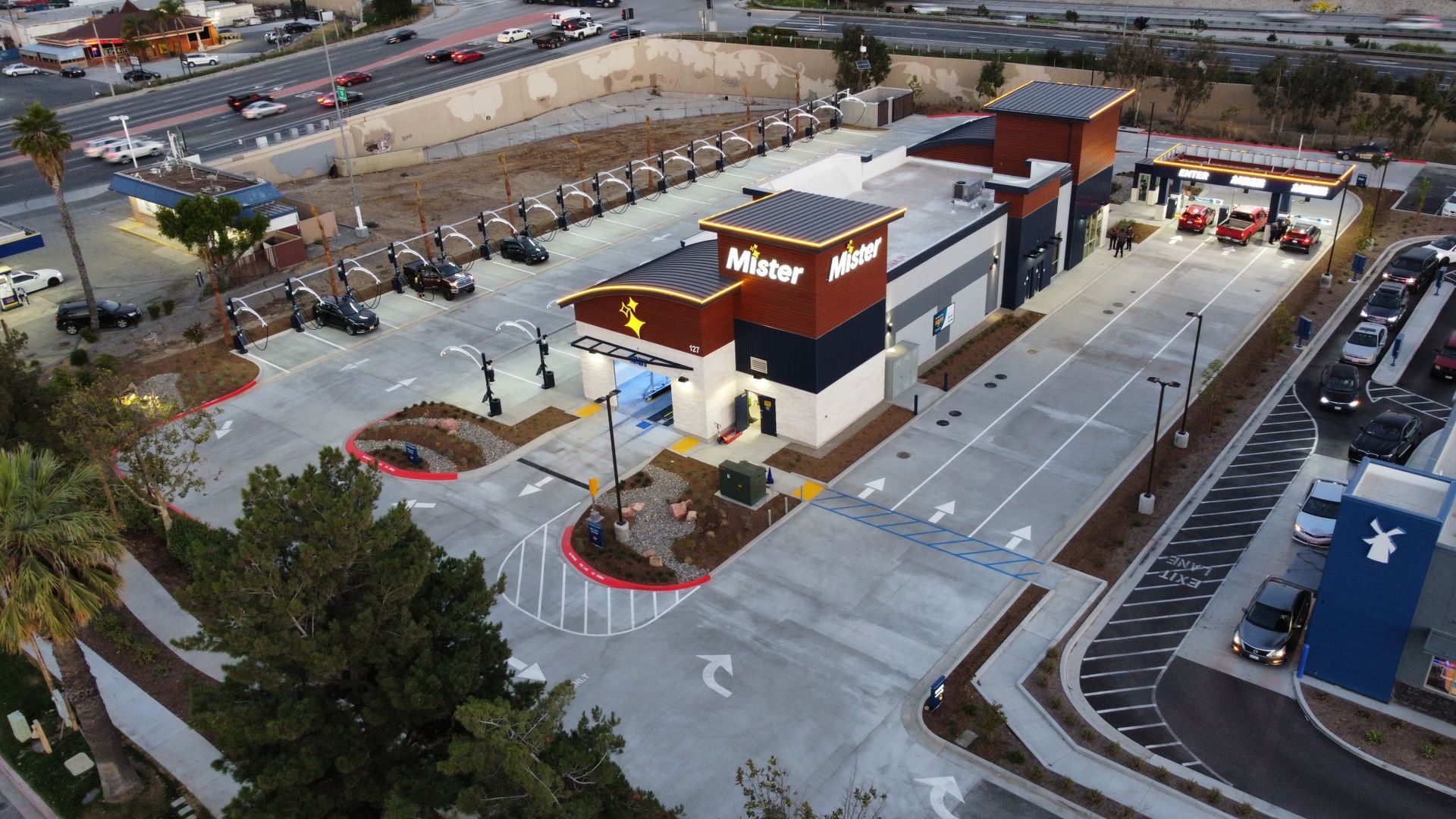 Aerial view of a fast-food restaurant and drive-thru parking lot at dusk