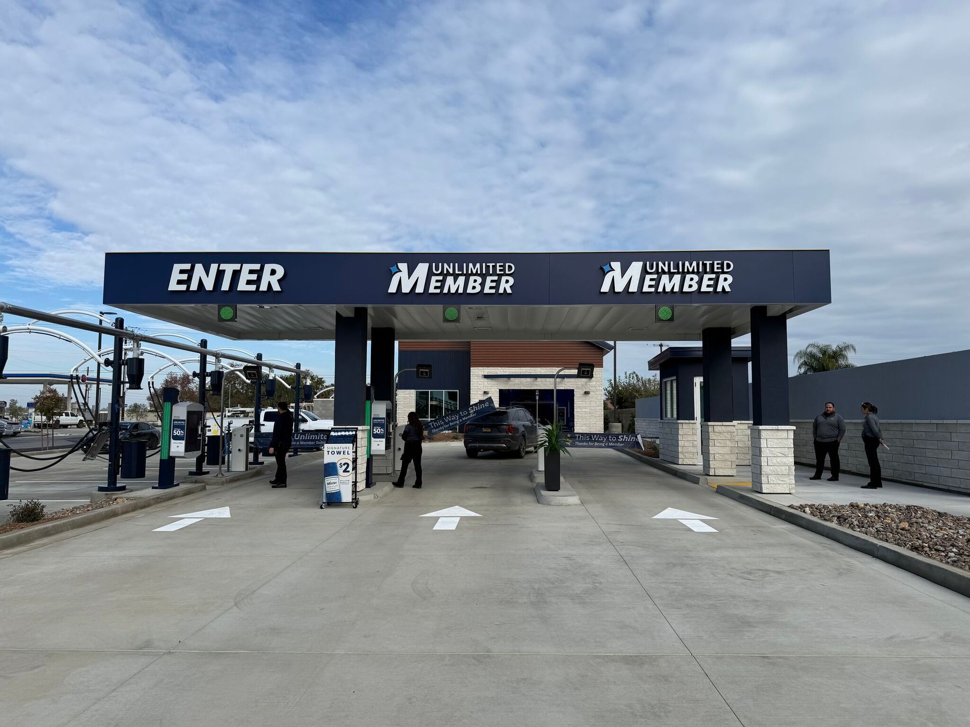 Entrance gate to a military base with “ENTER” and “Member” signs under a cloudy sky