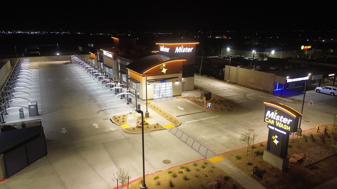 Nighttime aerial view of a brightly lit Meyer store parking lot and entrance with a large sign.