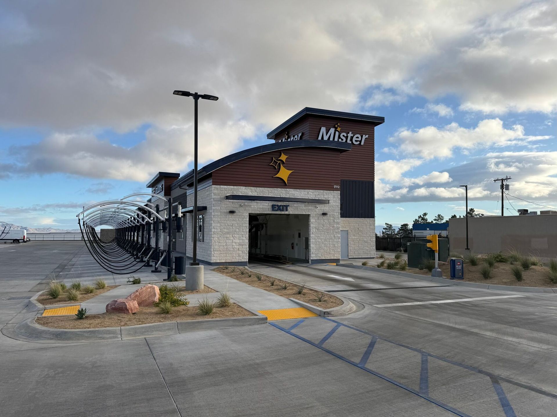 Mister station entrance with parked shuttle under cloudy sky on a roadside lot