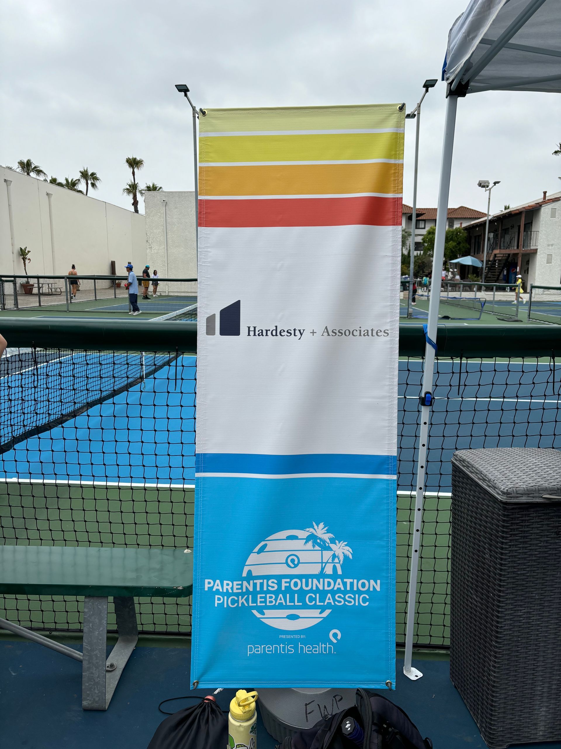 Blue swim lane banner with yellow and red stripes at an outdoor poolside event.