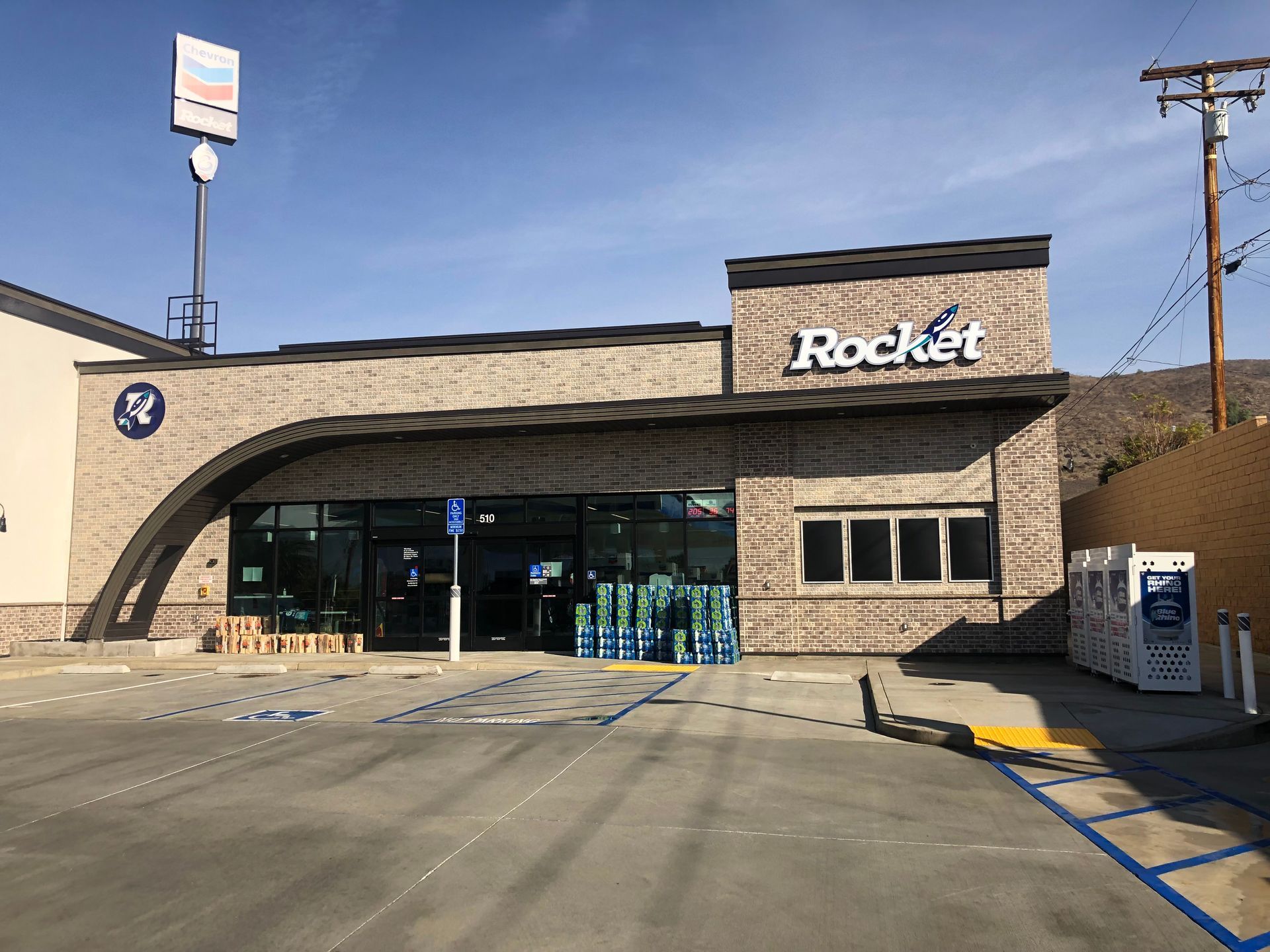 Rocket convenience store storefront with stone facade, glass entrance, and empty parking lot