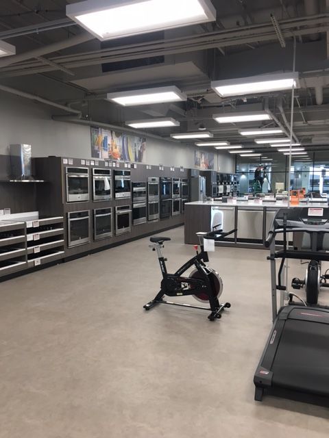 Gym with a stationary bike, treadmills, and weight machines under bright ceiling lights