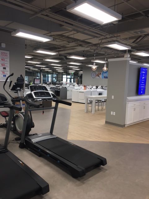 Modern gym interior with treadmills, exercise bikes, and a bright open workout area
