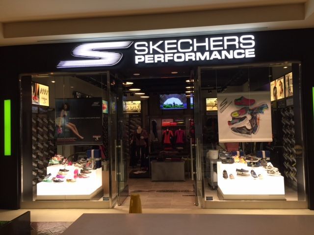 Skechers Performance store entrance with illuminated logo and shoe displays inside