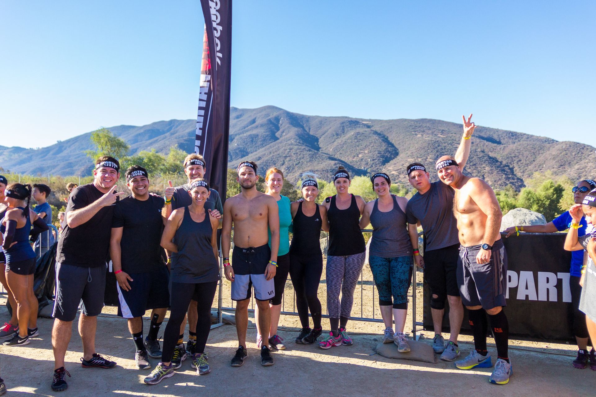Group of runners posing at a start line outdoors with mountains in the background