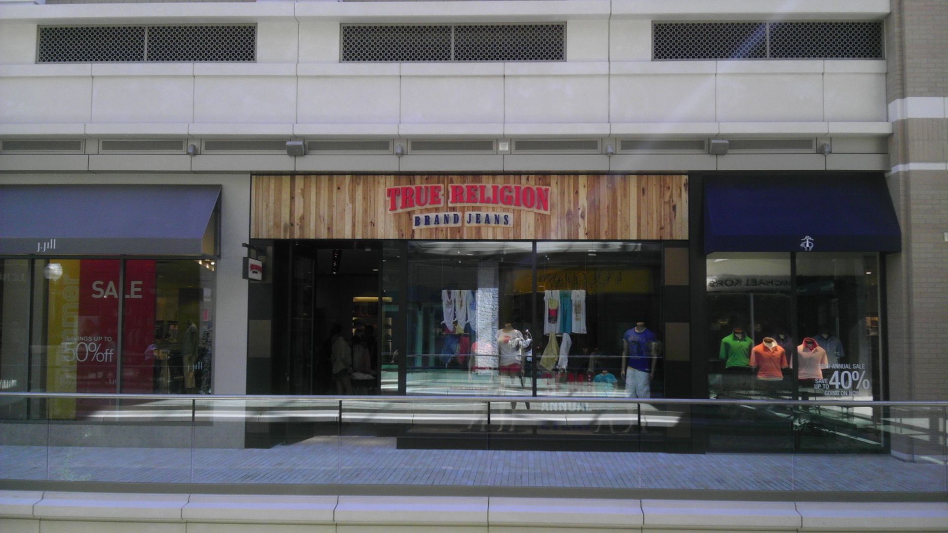 Street-front storefront with mannequins in the window and signs above the entrance.