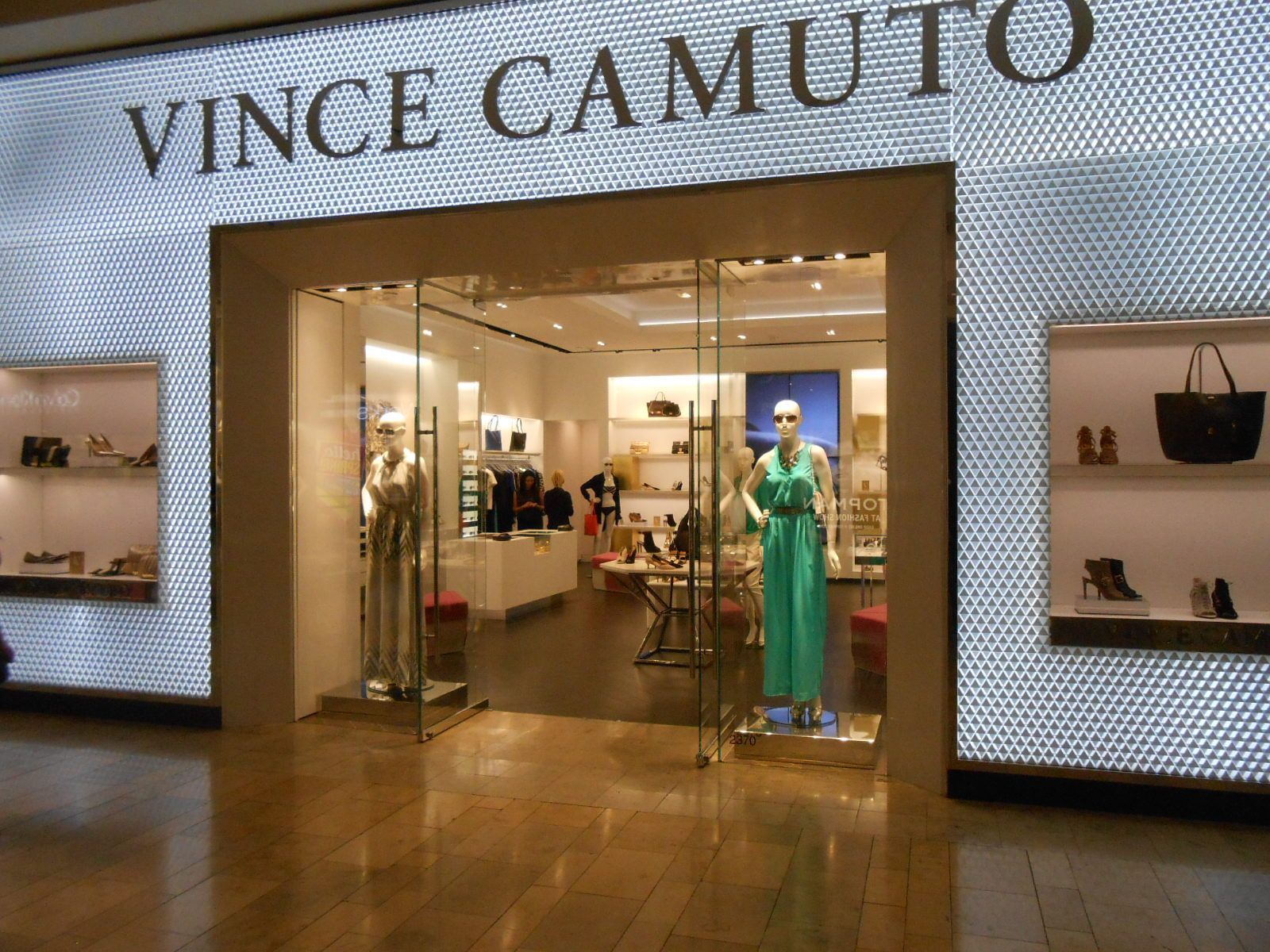 Vince Camuto store entrance with shoes and handbags on display; mannequin in a green dress inside