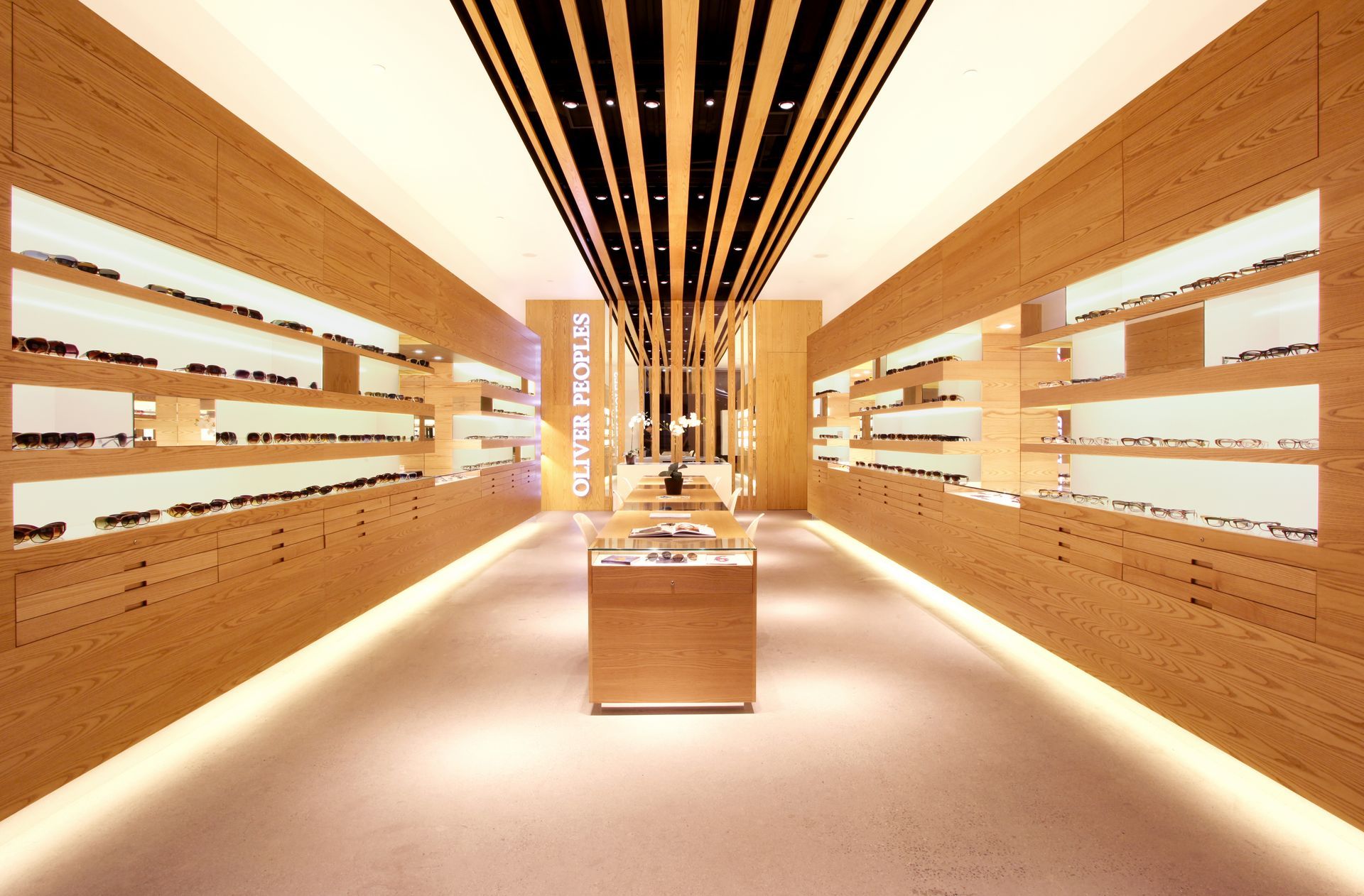 Modern retail aisle with wood-paneled walls, warm lighting, and centered display shelves