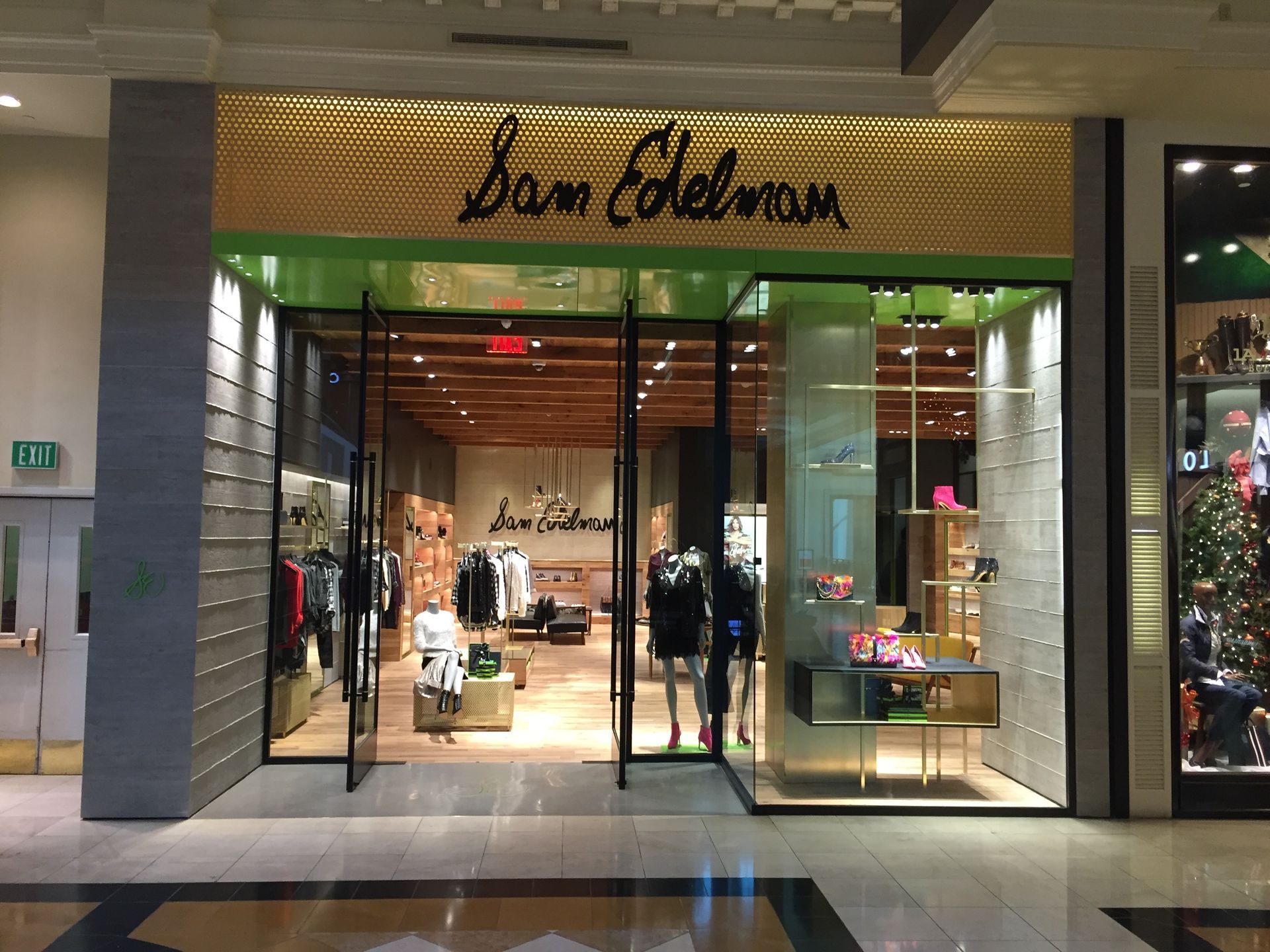 Storefront of a Sam Edelman shoe store in a shopping mall, with mannequins and bright display windows.