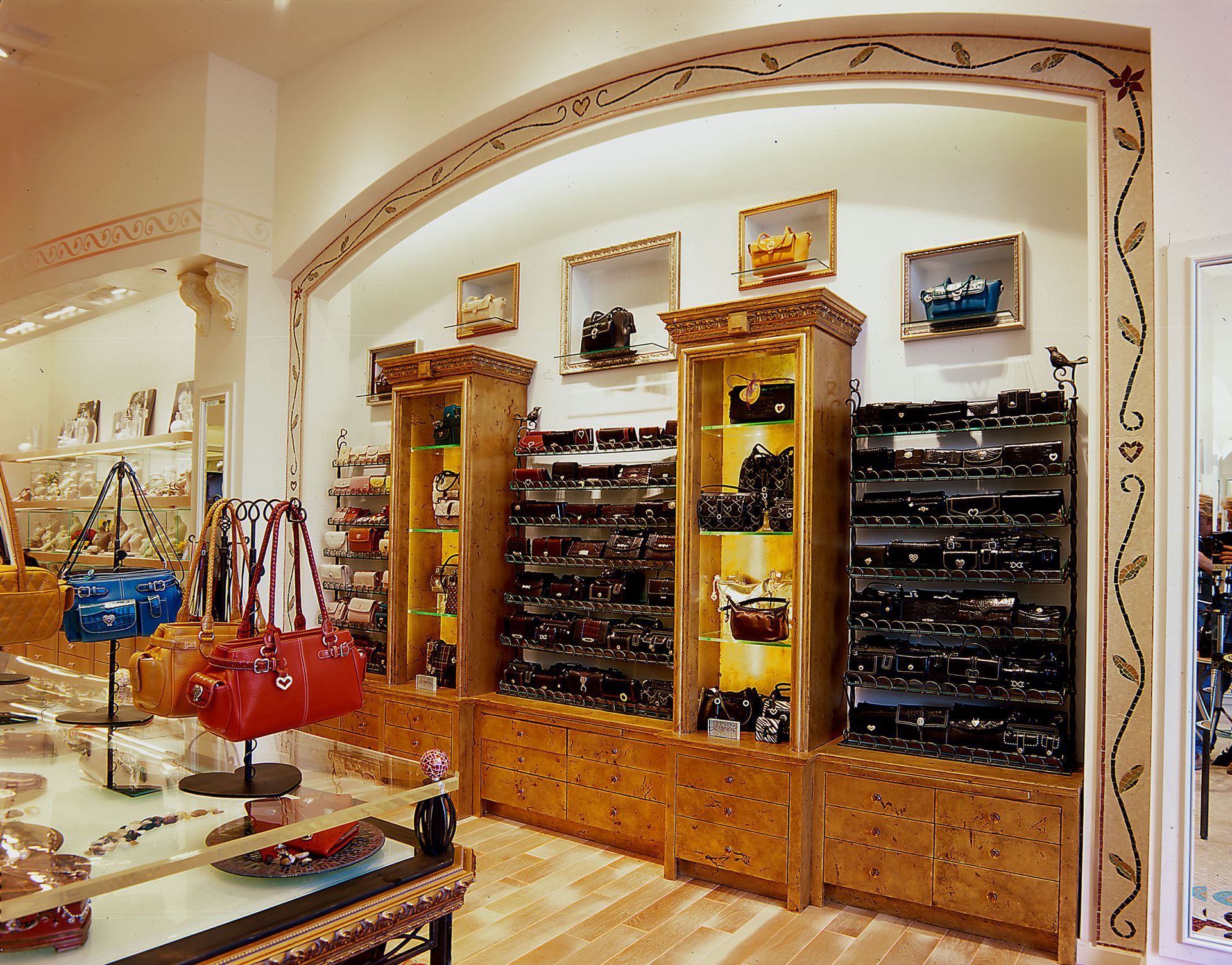 Boutique interior with handbags, sunglasses, and wooden display shelves in a bright arched room