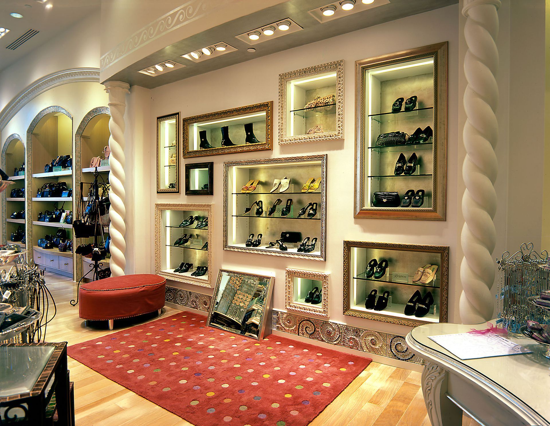 Upscale shoe boutique with shelves of shoes, red rug, and ornate cream walls