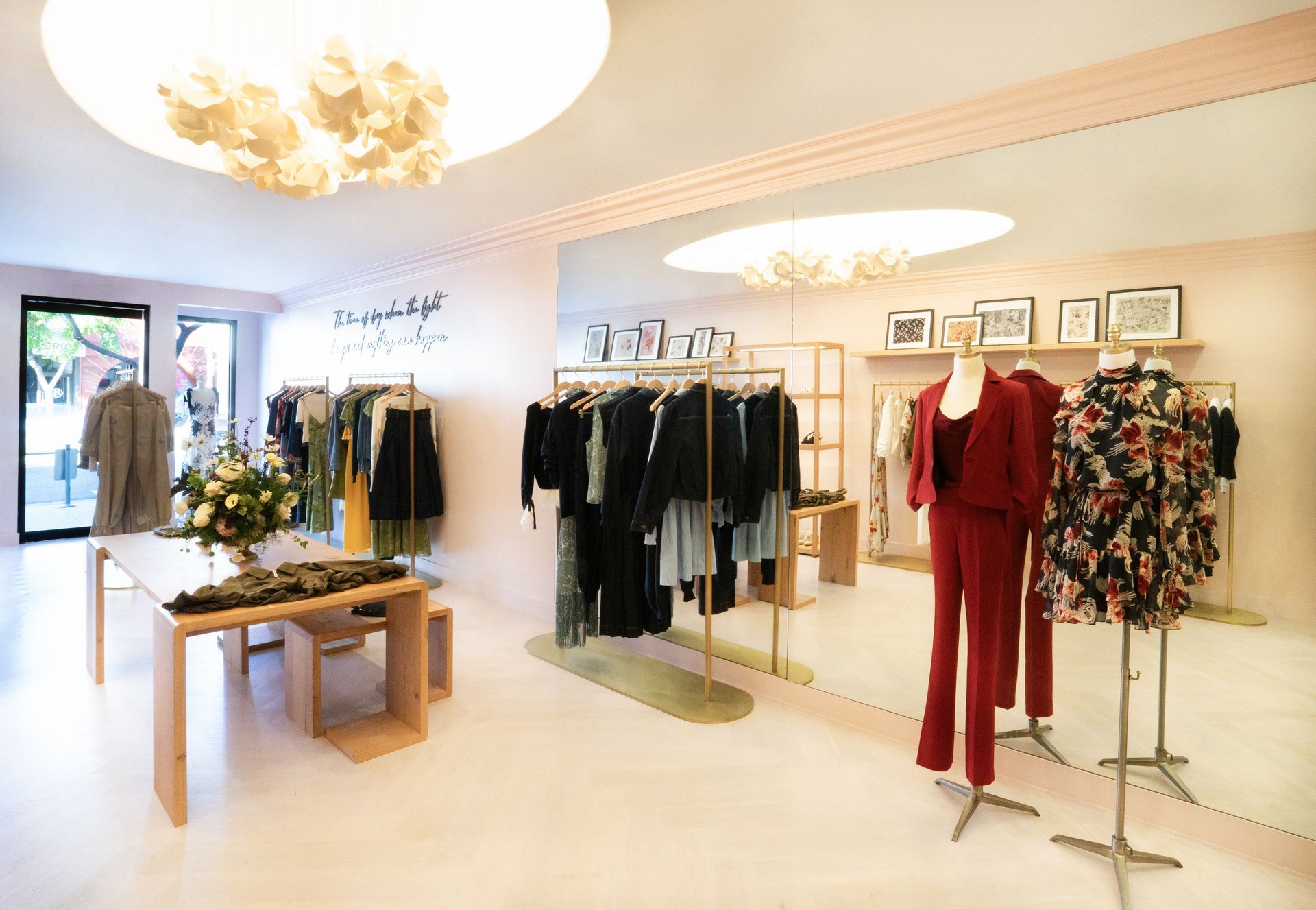 Bright clothing boutique with racks of dresses, shelves, tables, and warm ceiling lights
