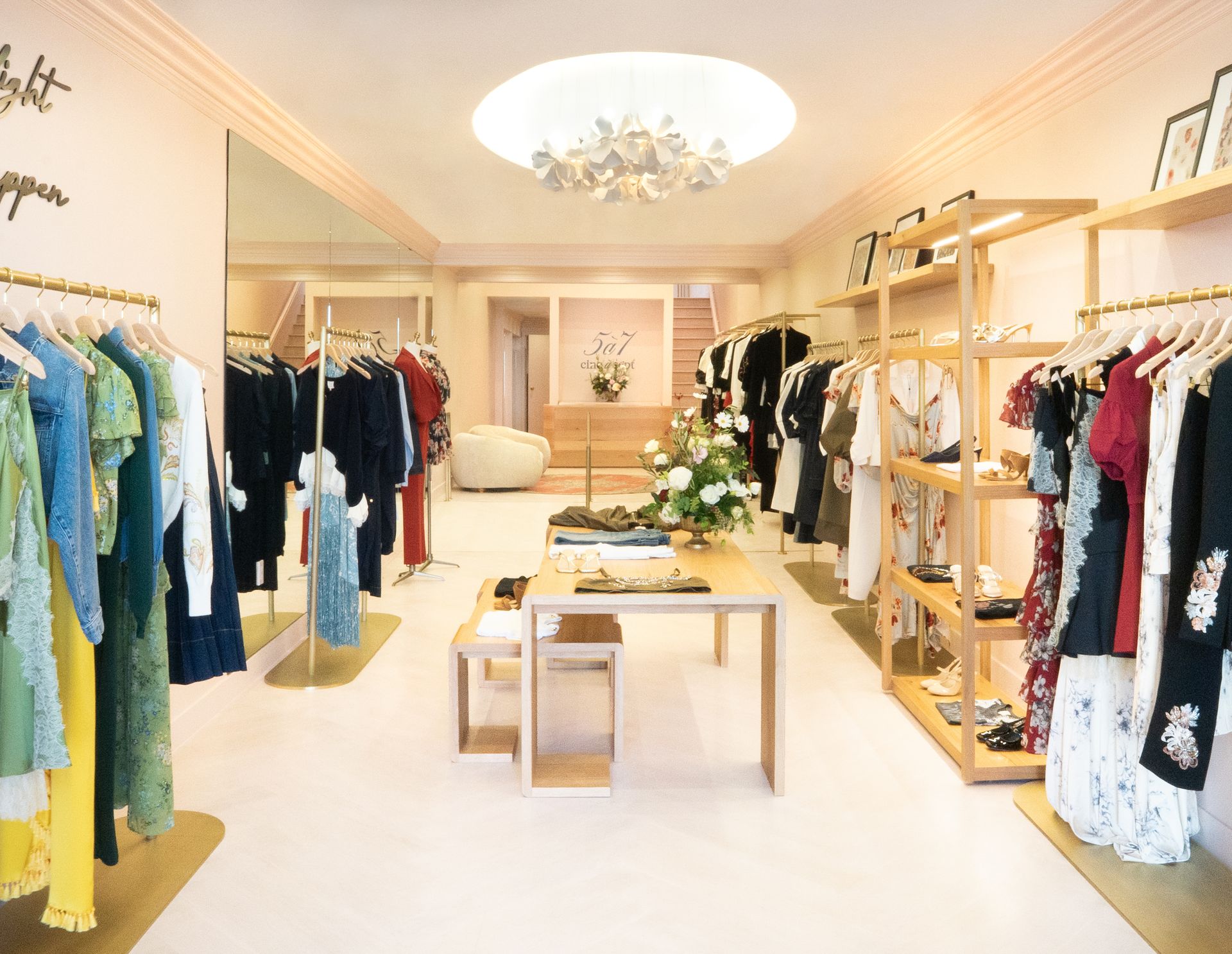 Bright boutique clothing store with racks of colorful clothes and a central display table