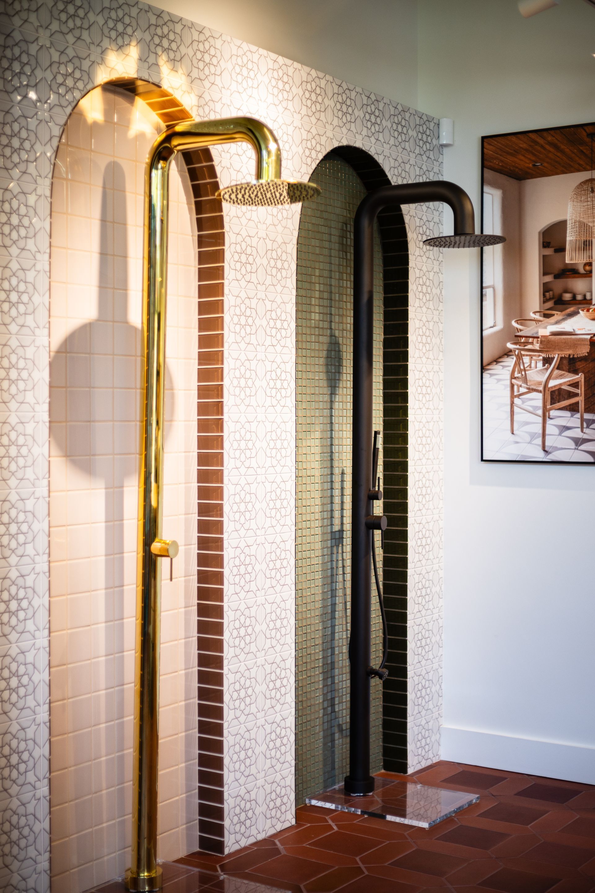 Three decorative vintage pumps or handrails displayed against a wall in a tiled room
