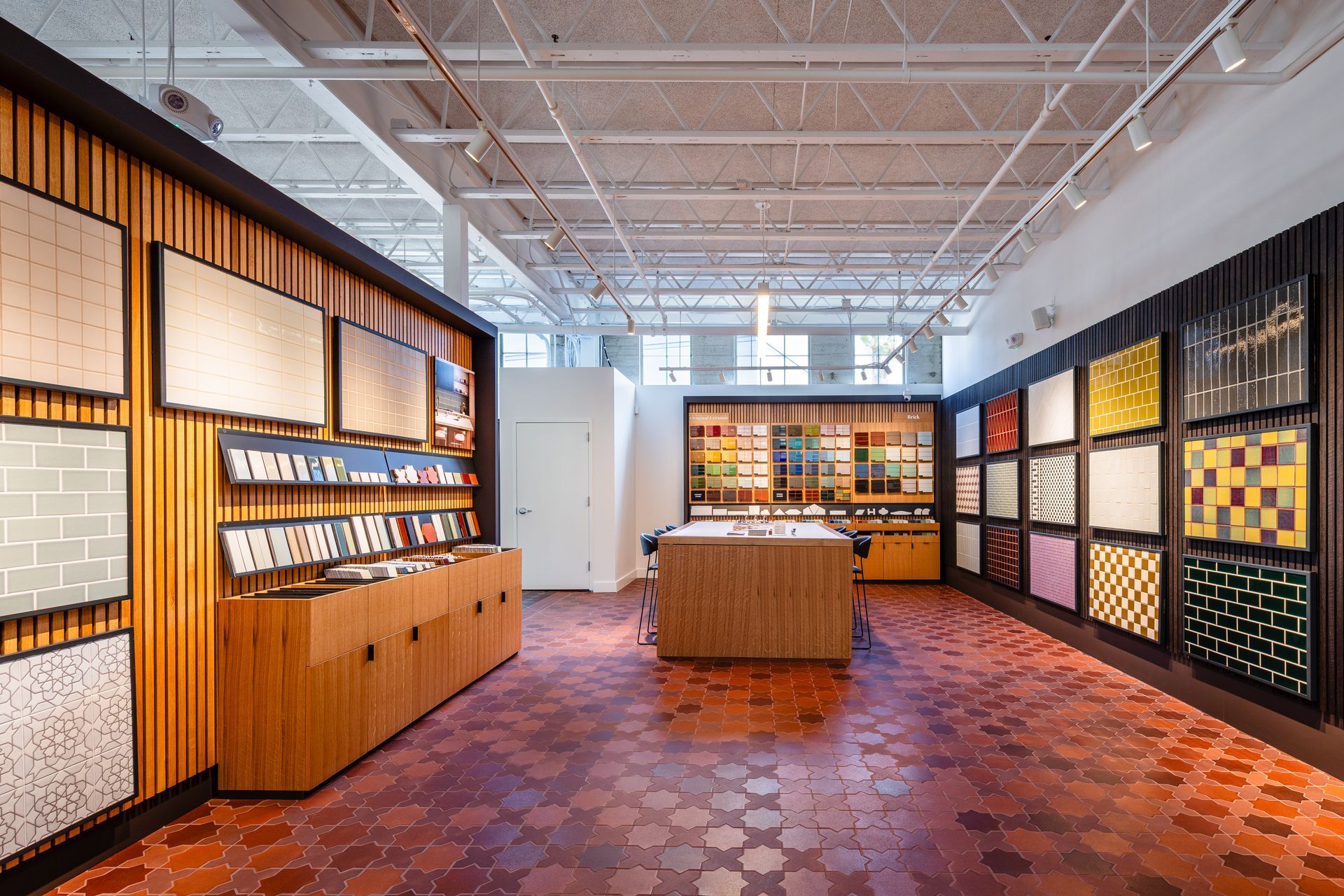 Modern retail showroom with wood display walls, shelves of products, and patterned carpet under bright ceiling lights