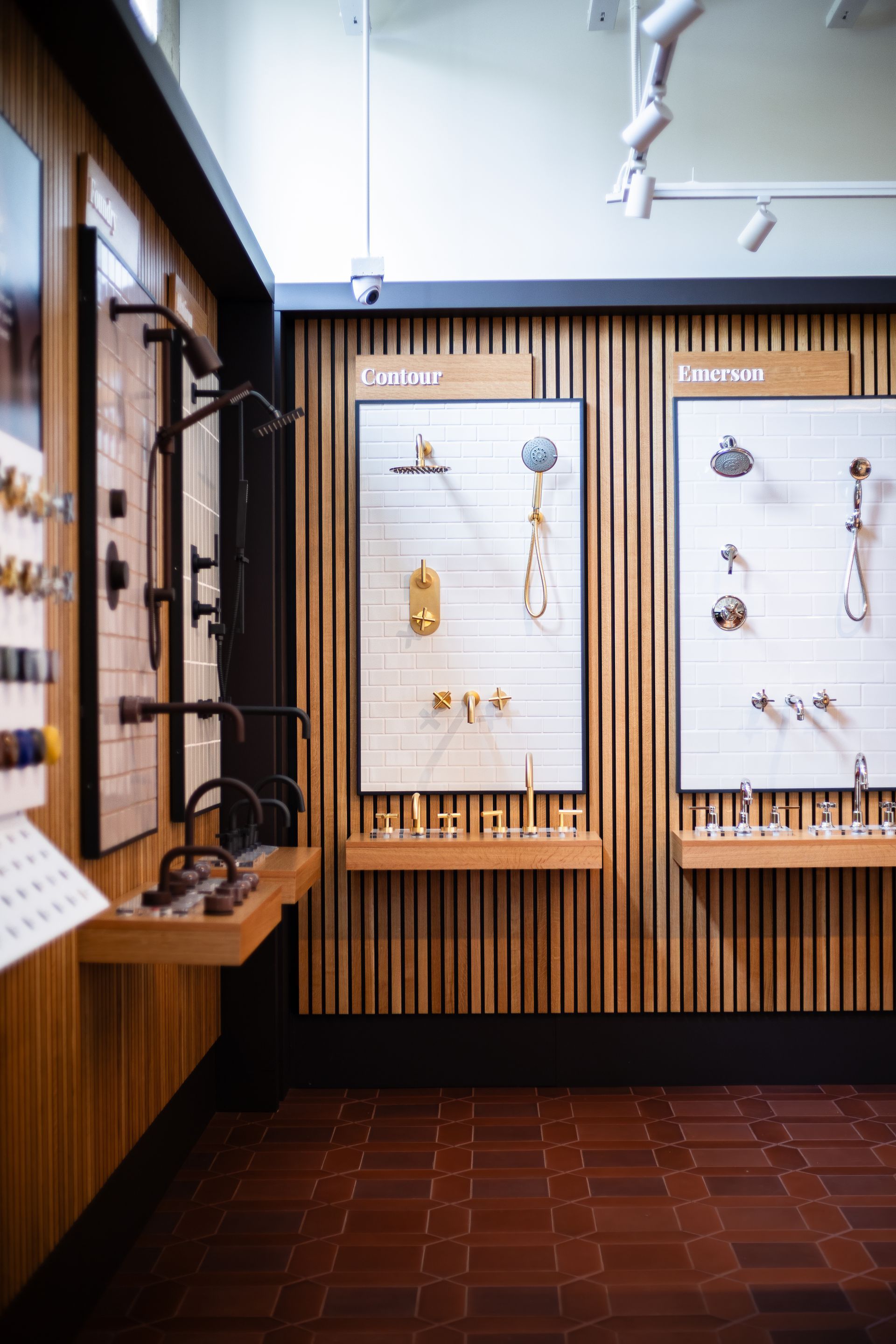Museum exhibit with framed jewelry displays, wood slat walls, and a tiled floor