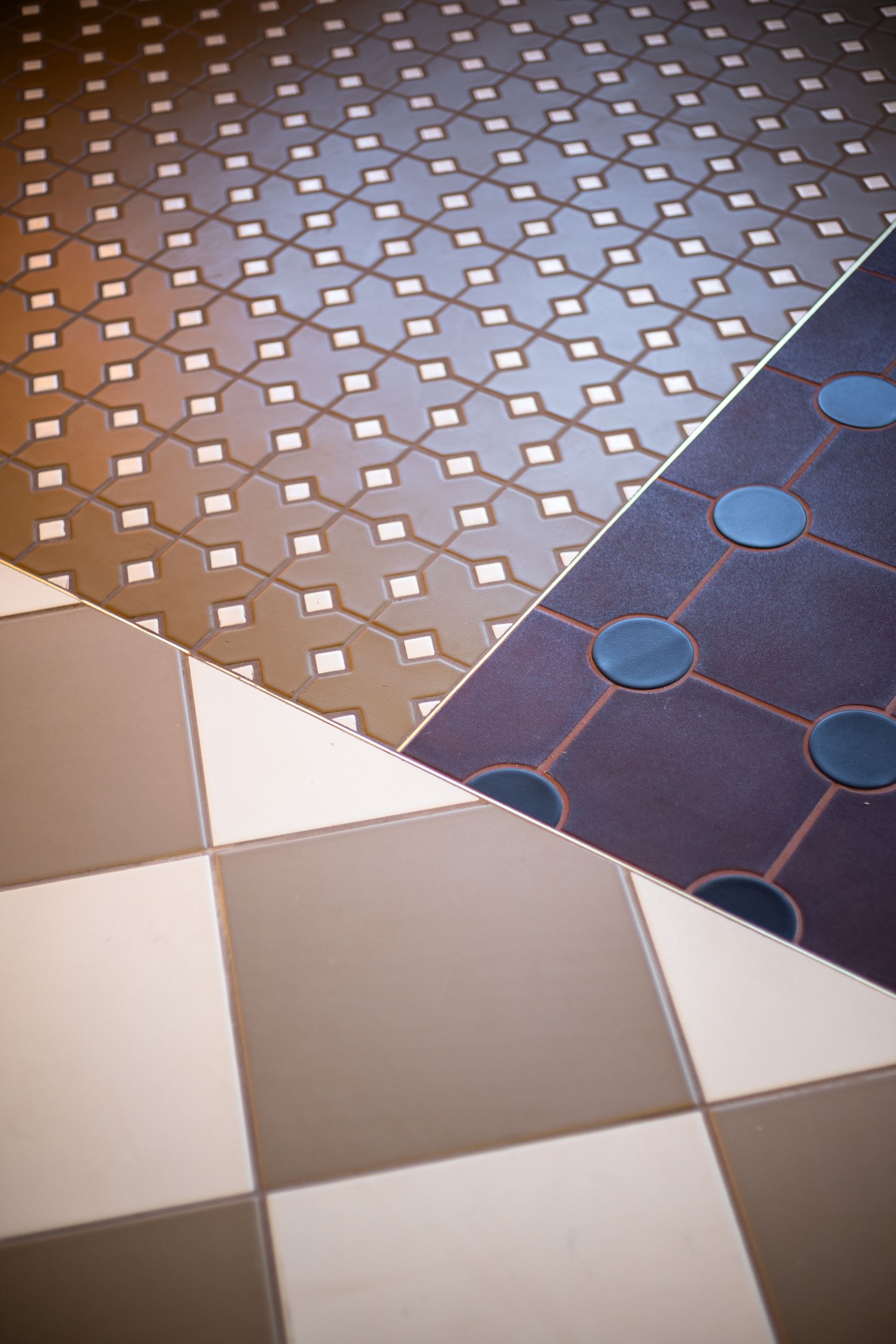 Assorted patterned tile samples in brown, blue, and white arranged in overlapping sections