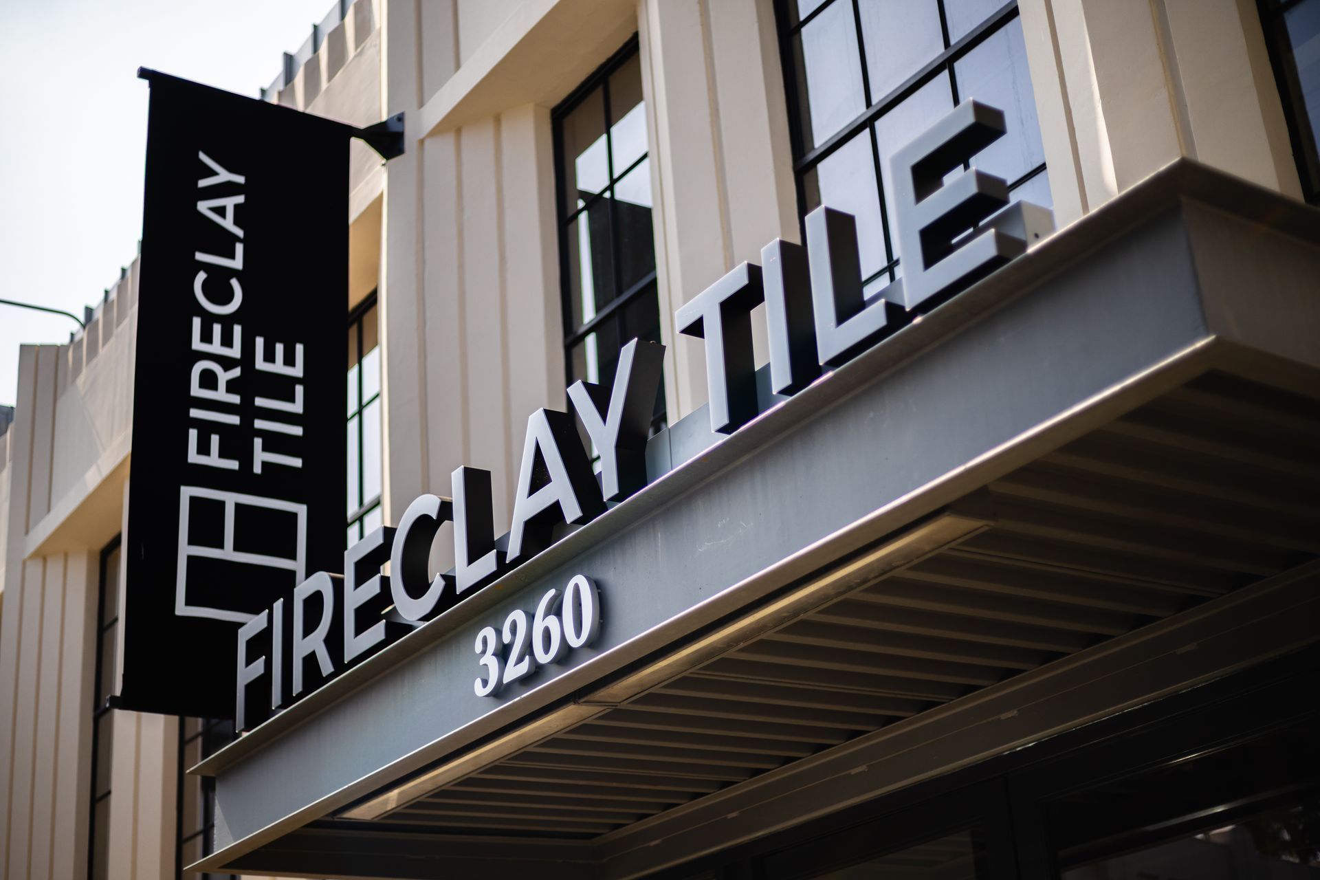 Fireclay Tile storefront sign above an awning, with address 3260