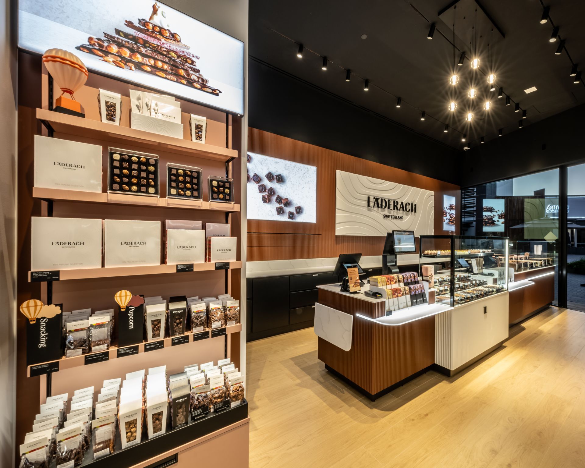 Modern coffee shop interior with shelves of packaged products and a central display counter