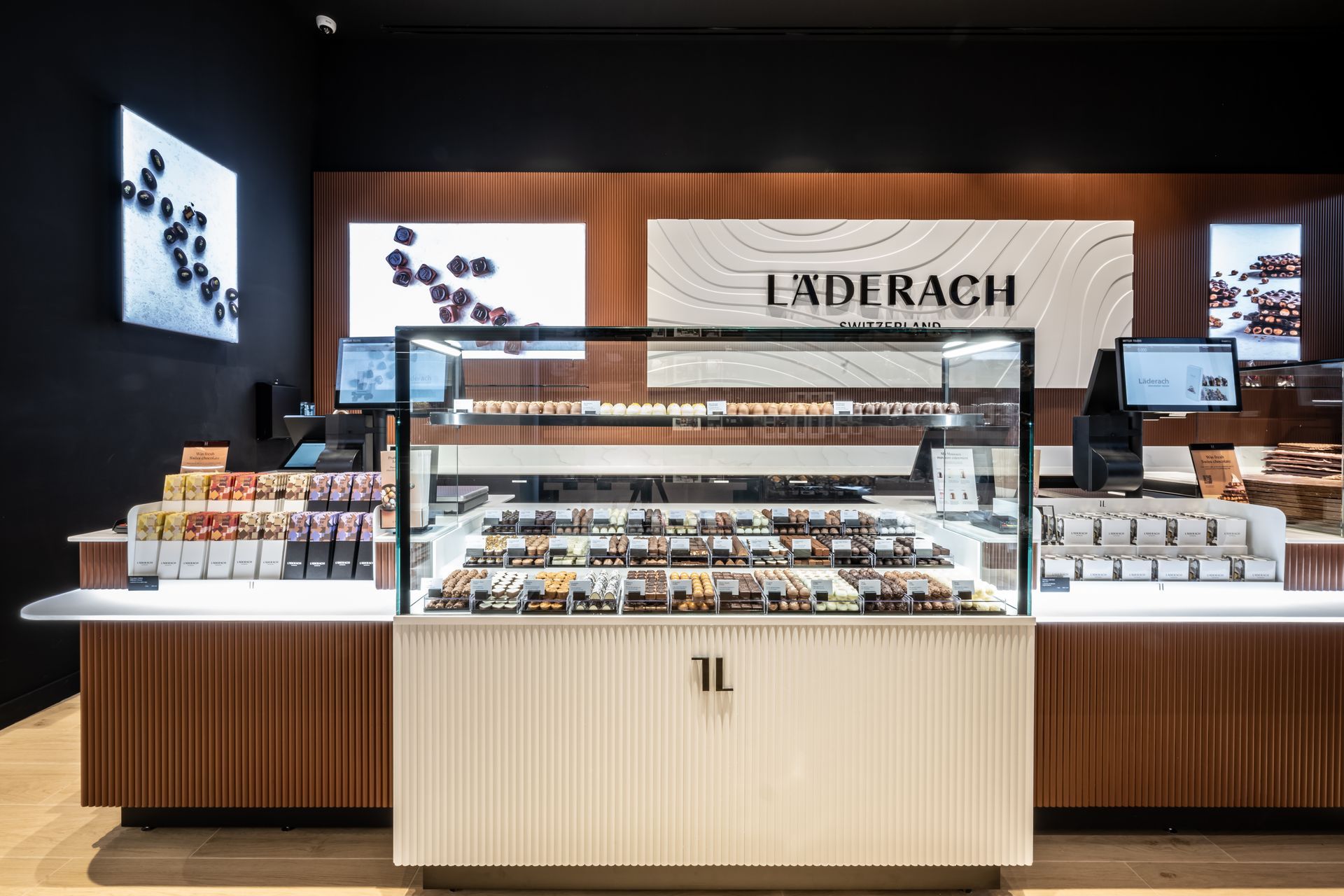 Luxury bakery display counter with pastries and branded signage inside a modern store